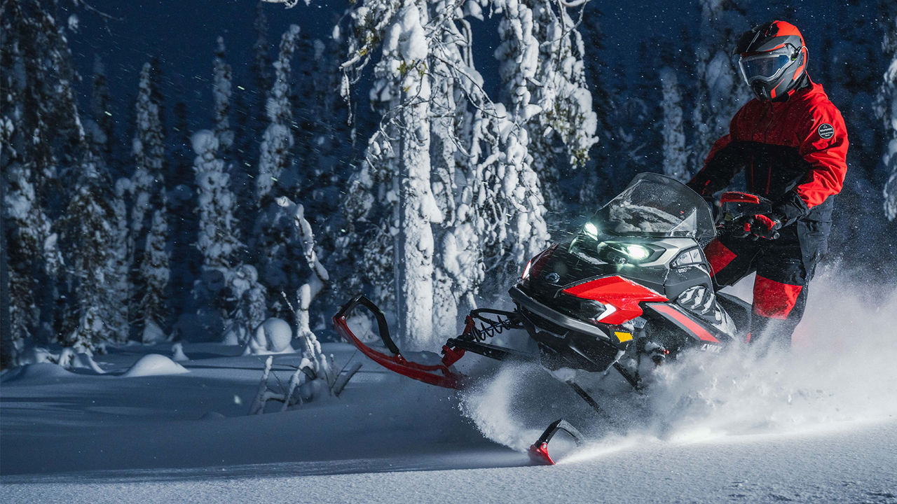 Lynx Xterrain RE snowmobile riding off trail in dark forest