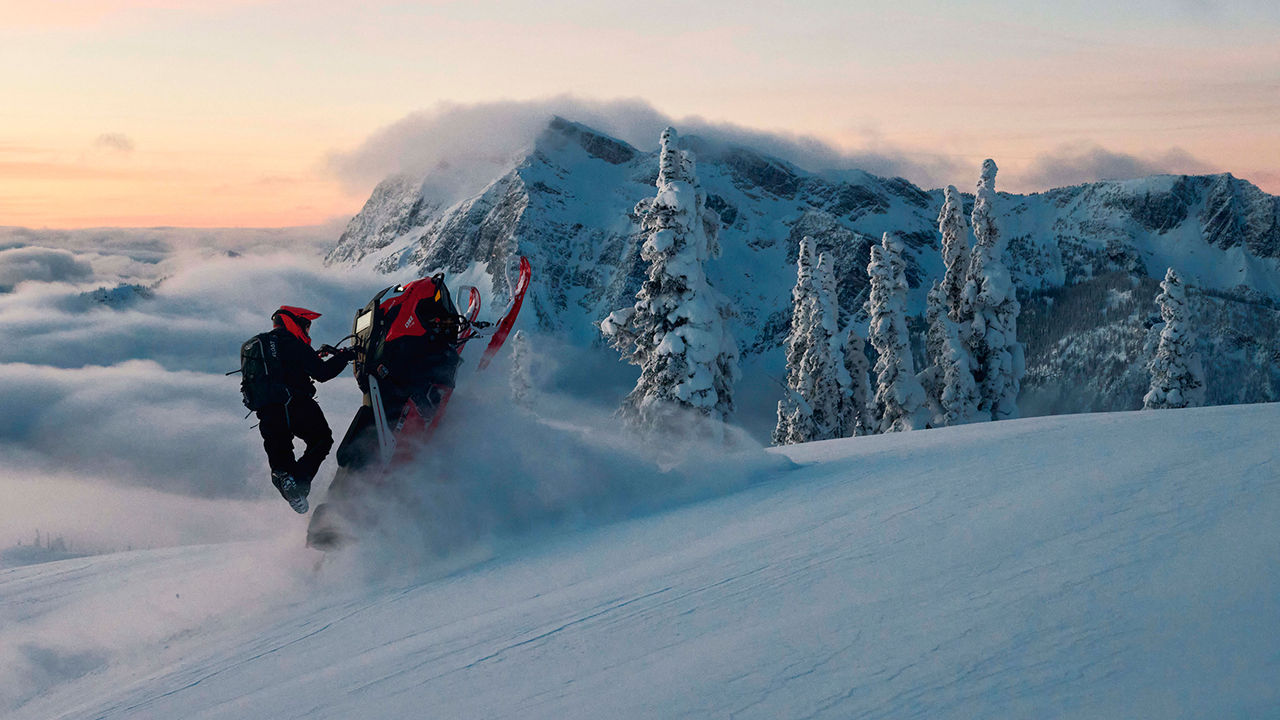 Lynx Shredder RE snowmobile climbing hill in mountains