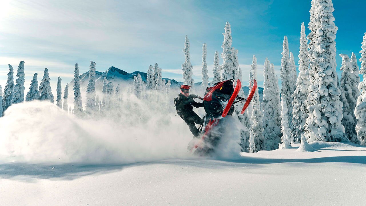 Lynx Shredder RE snowmobile making wheelie on the top of the mountain