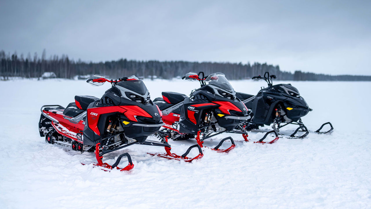 Lynx Shredder RE snowmobile taking big air between trees