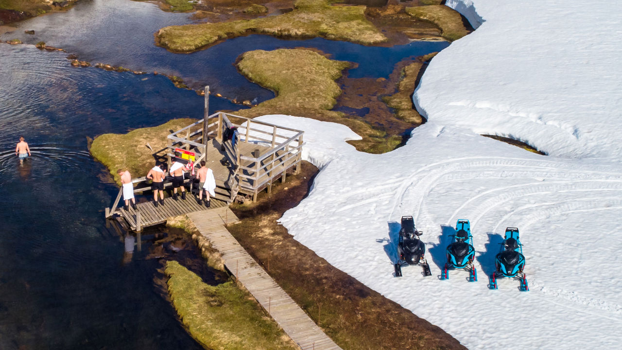 Lynx riders going in the hot springs next to their sleds