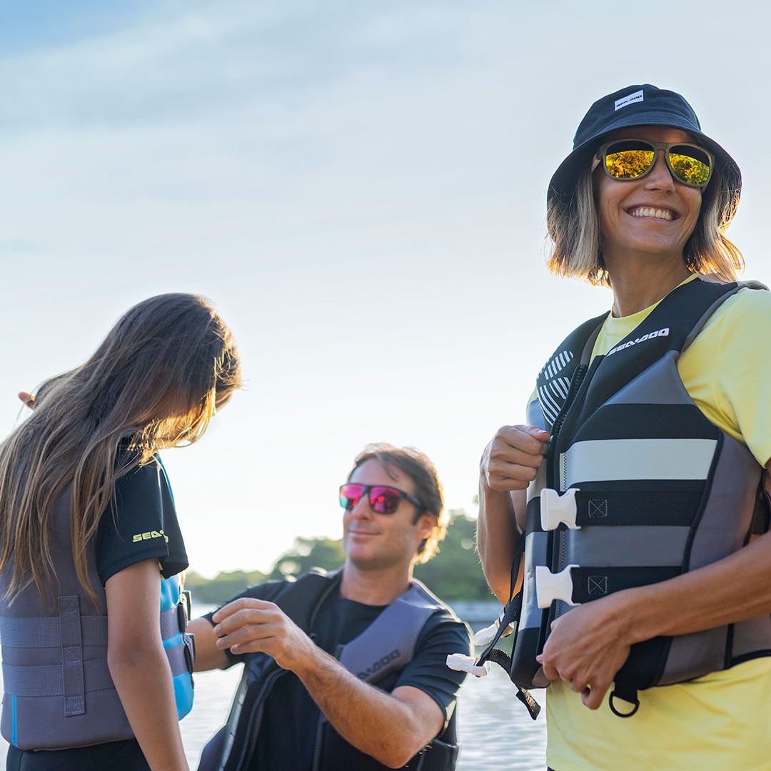 Man securing a Sea-Doo personal floatation device (PFD) on his daughter
