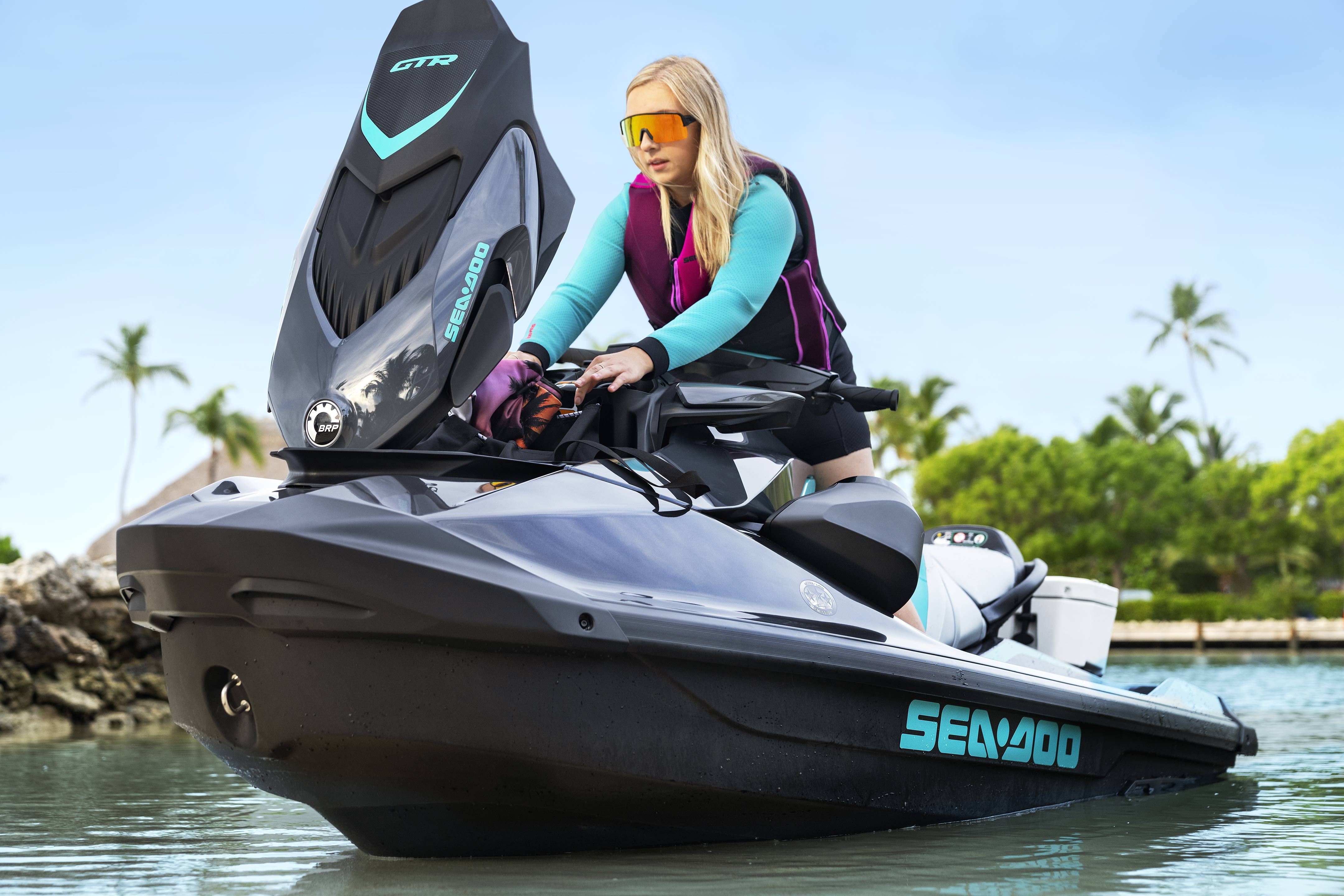 Rider storing items in her Sea-Doo GTR personal watercraft storage bin