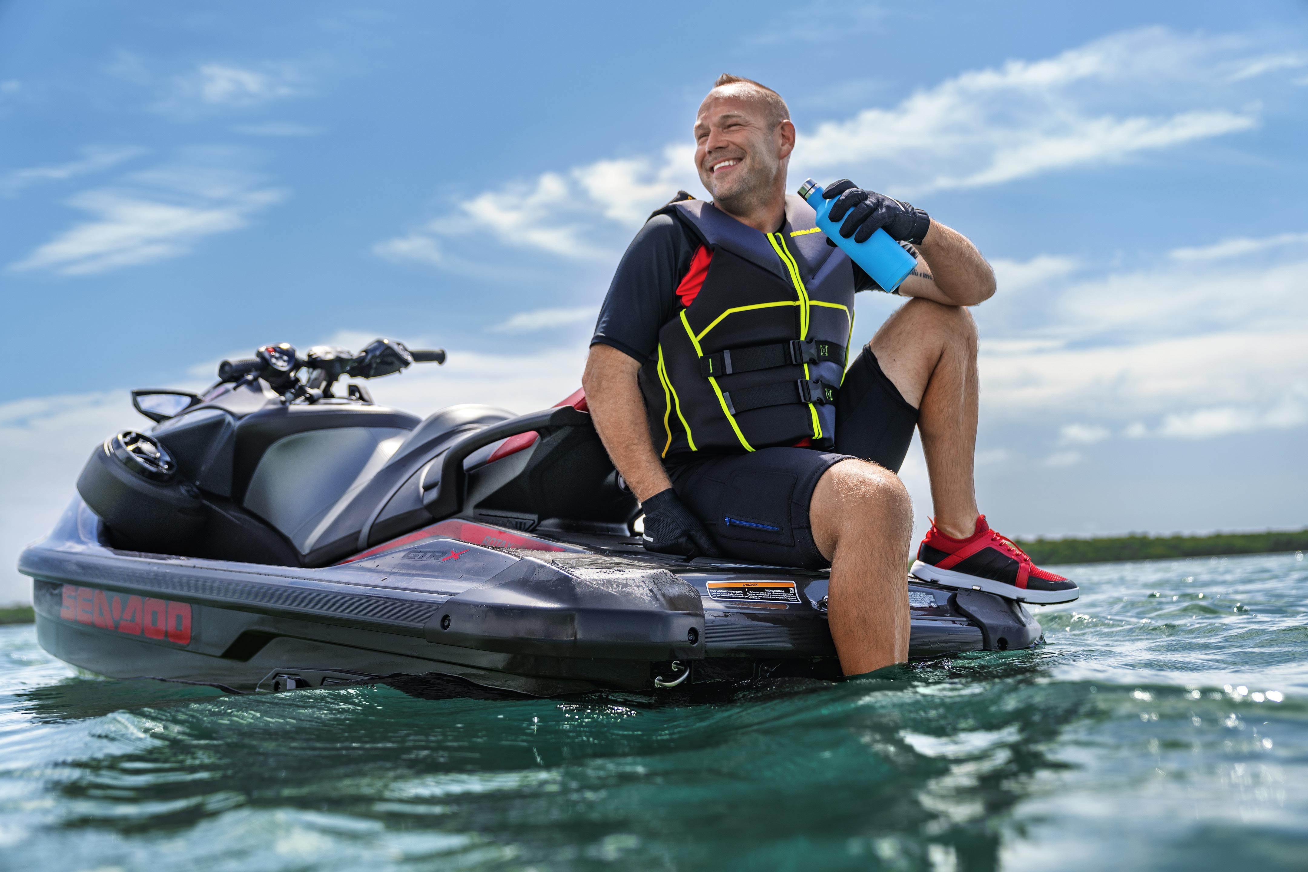 Man sitting on the back of his 2024 Sea-Doo GTR personal watercraft