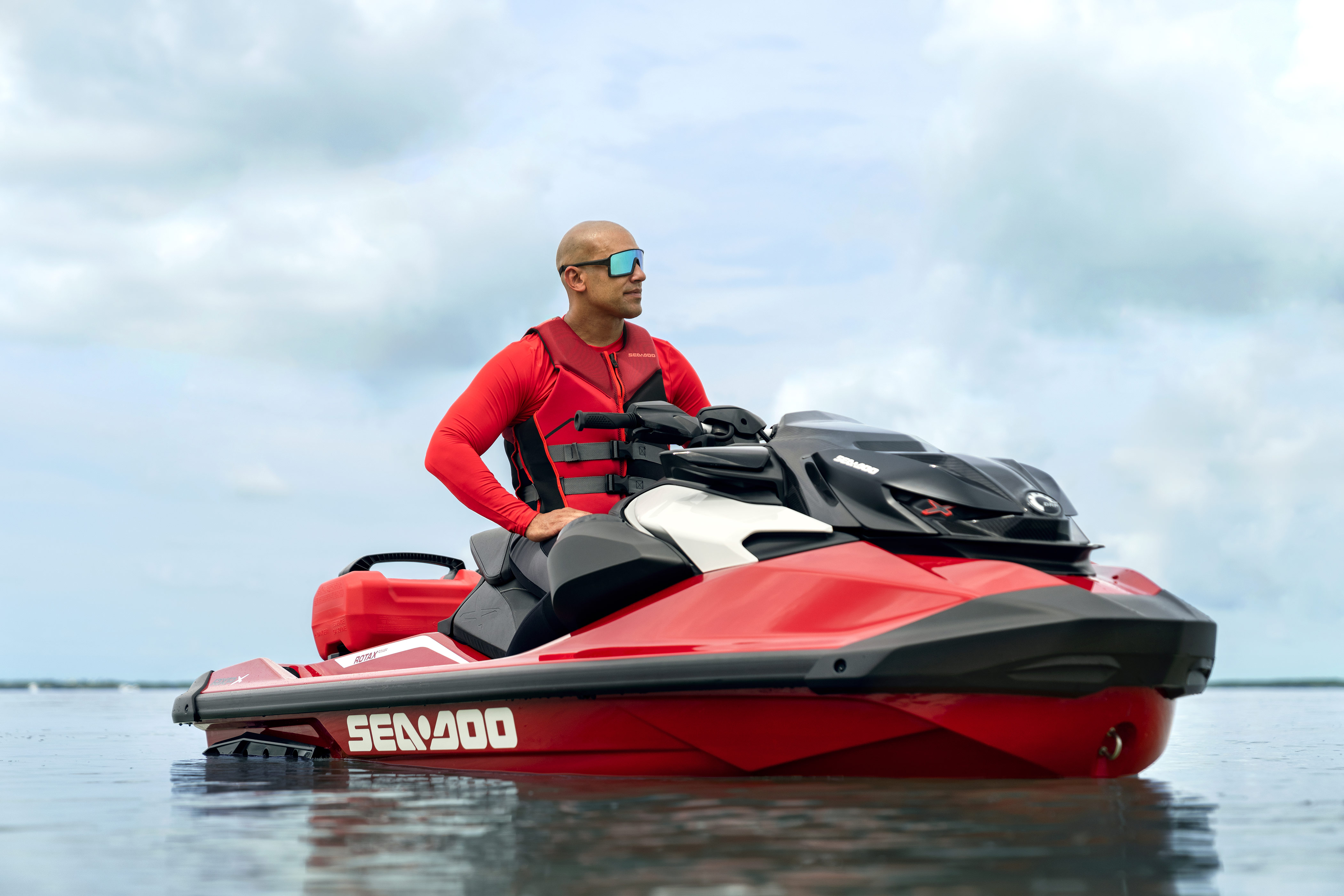 Čovjek sjedi na neaktivnom osobnom plovilu Sea-Doo RXP-X