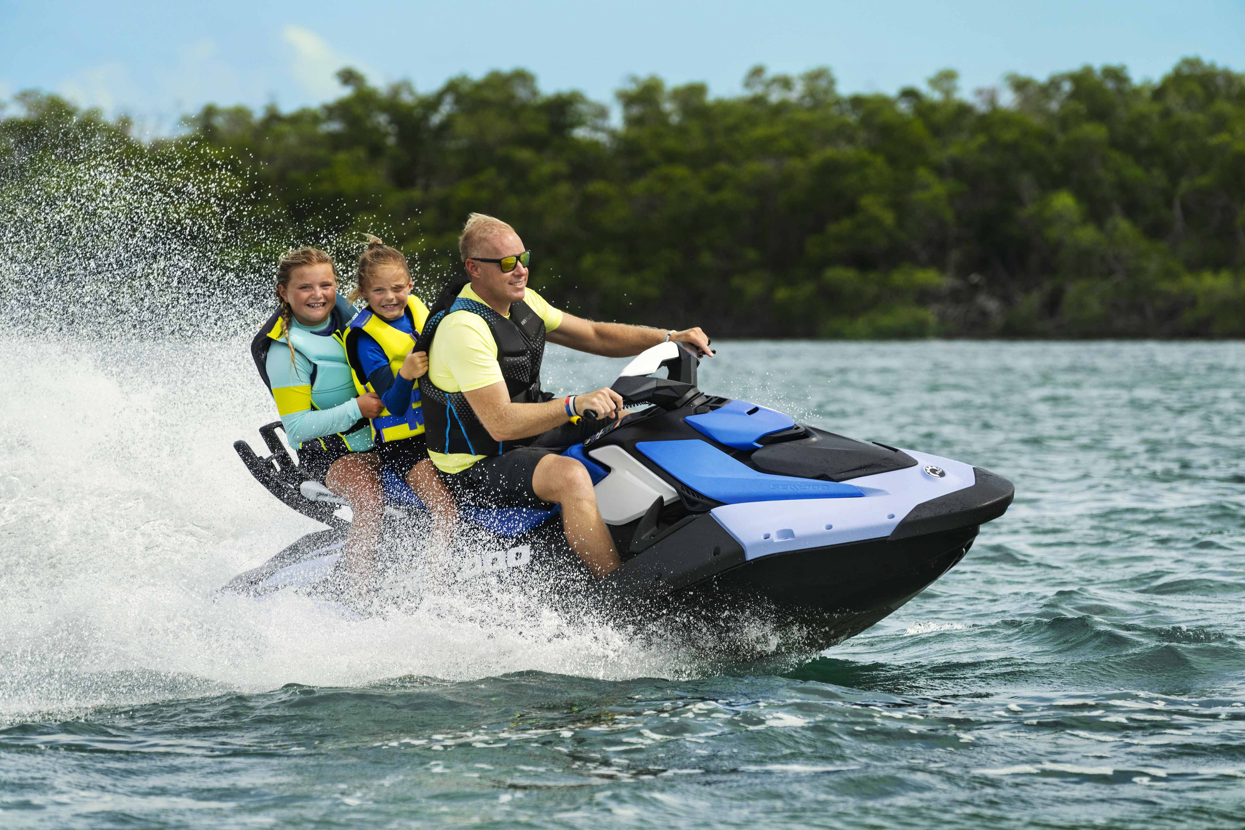 Father and his daughters enjoying a ride on a Sea-Doo Spark personal watercraft