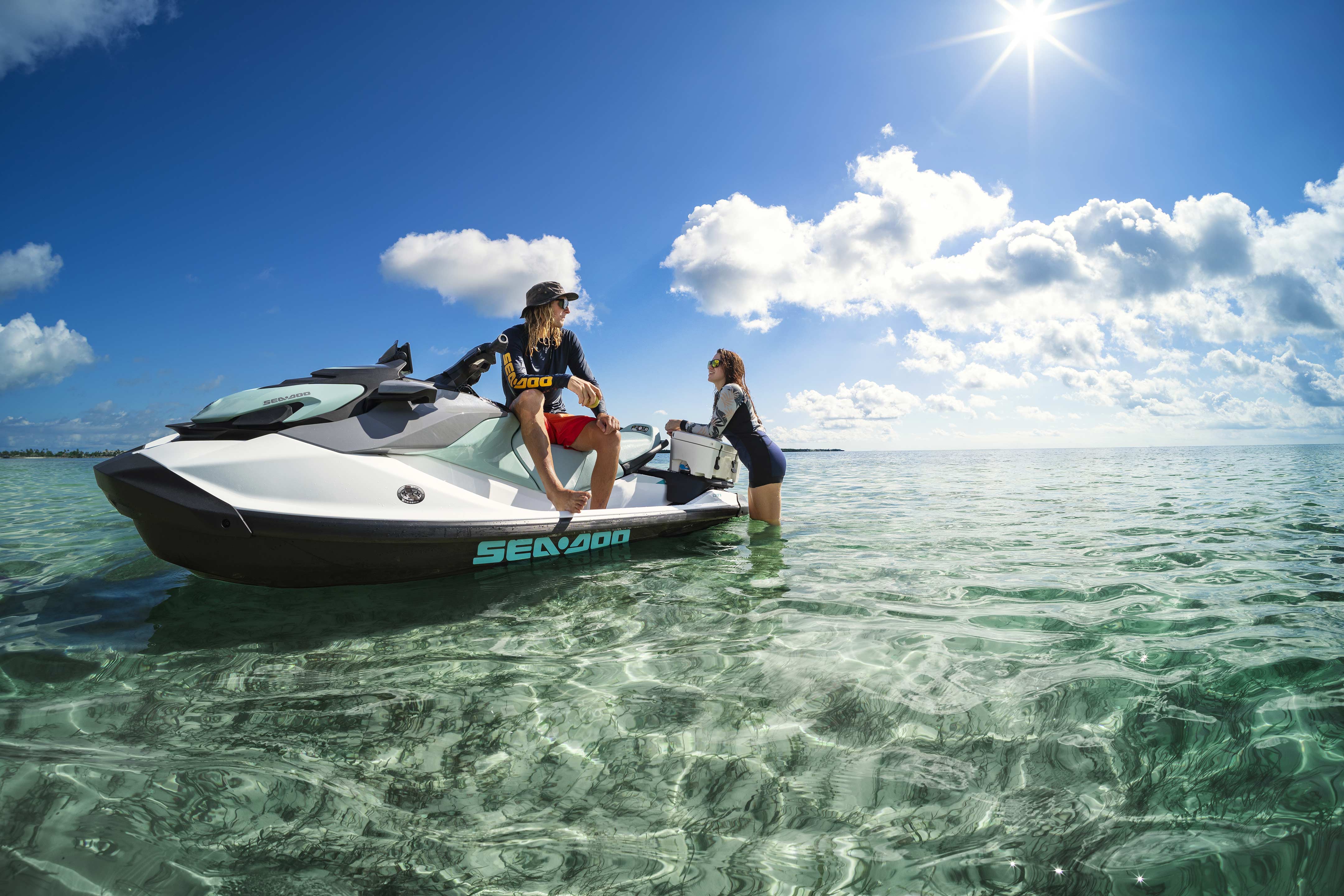 Two women talking on an idle recreational Sea-Doo GTI