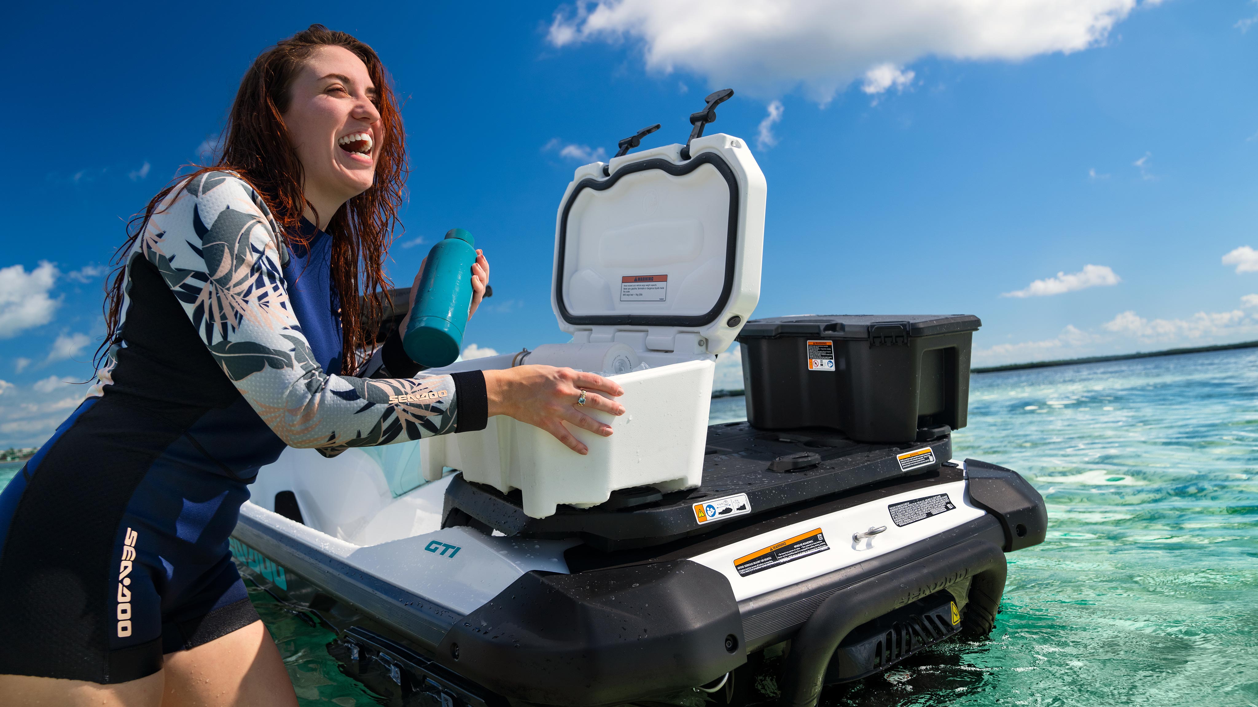 Woman using a LinQ Cooler set on her Sea-Doo GTI personal watercraft