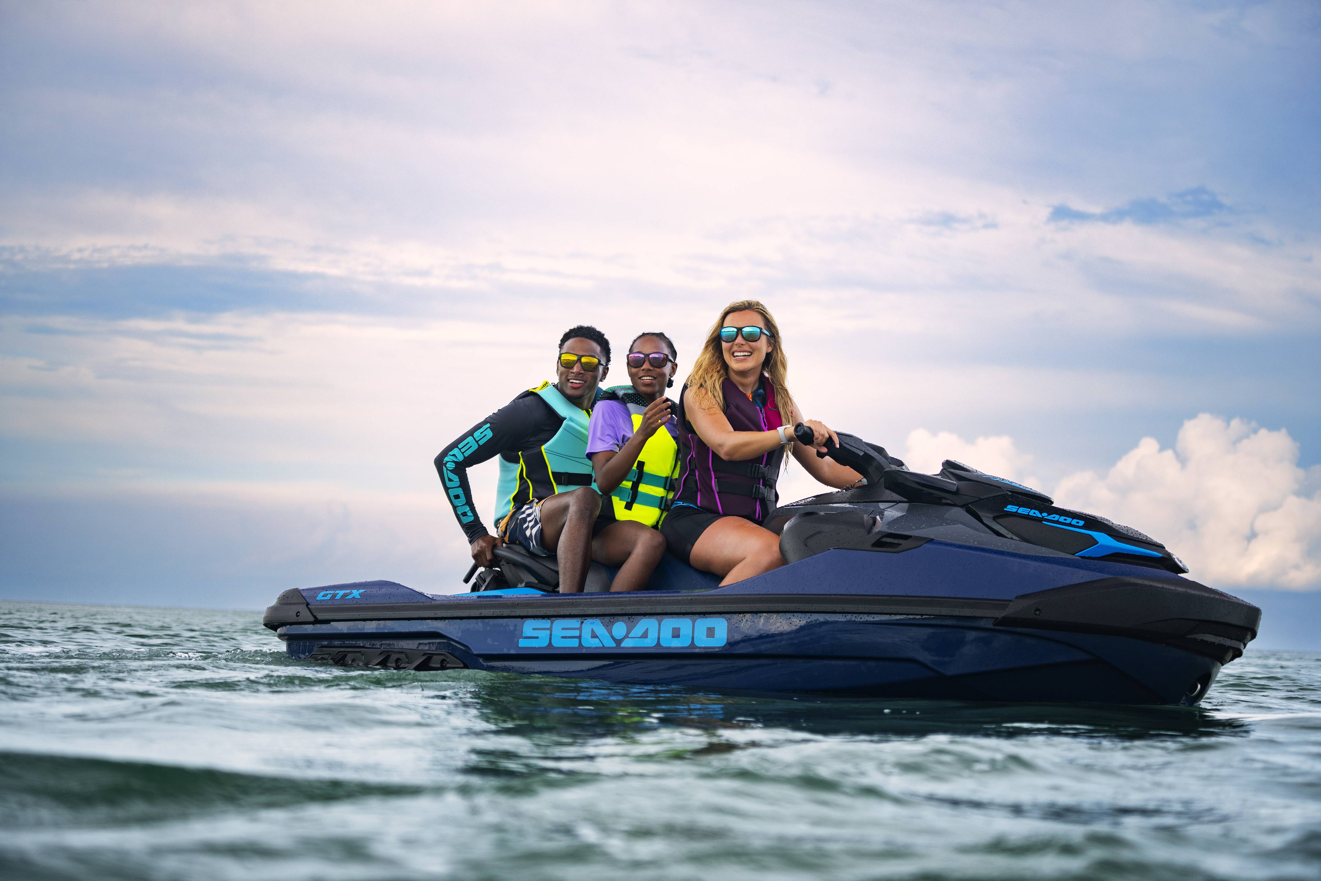 Three friends sitting on a 2024 Sea-Doo GTX personal watercraft