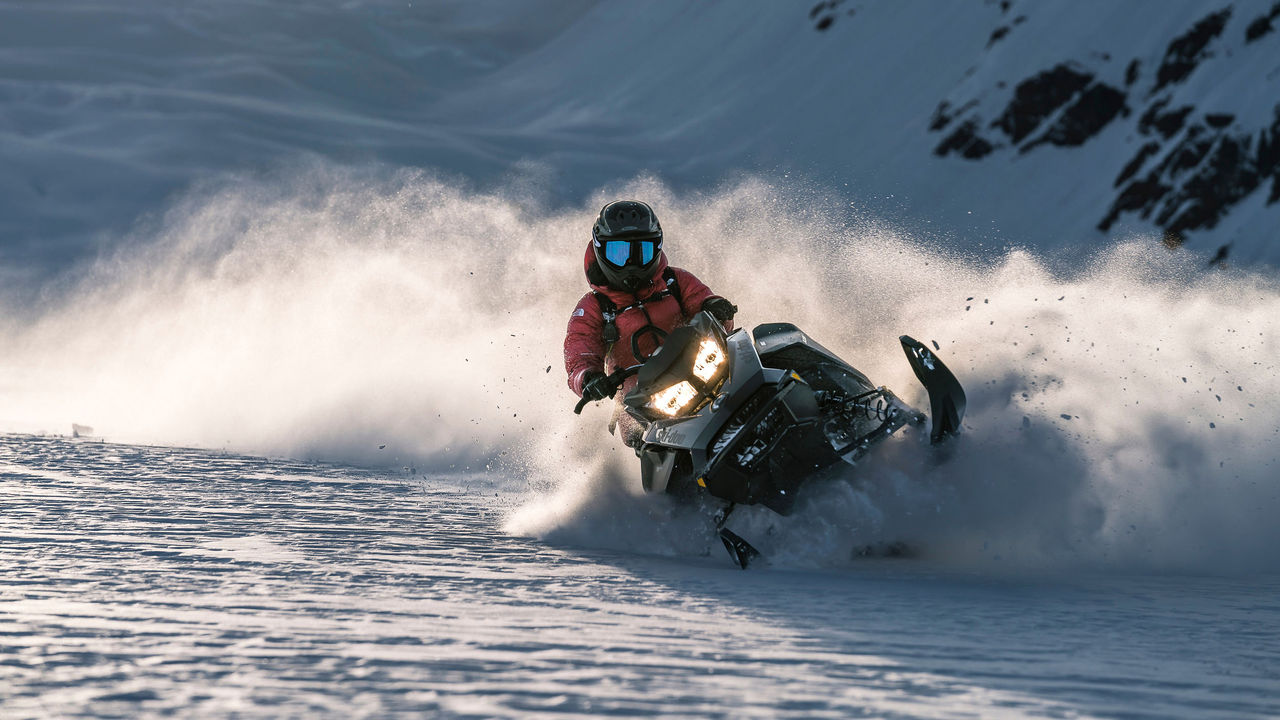 Women riding a Ski-Doo in powder