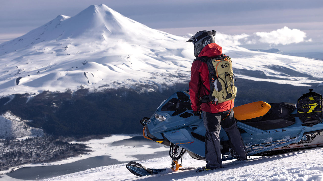 Muž jazdí na Ski-Doo na vrchole hory v Chile