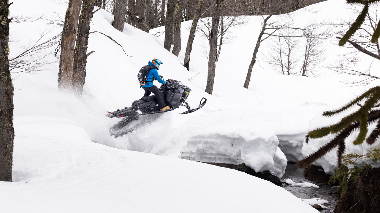 Muž skáče cez vodu na jeho Ski-Doo