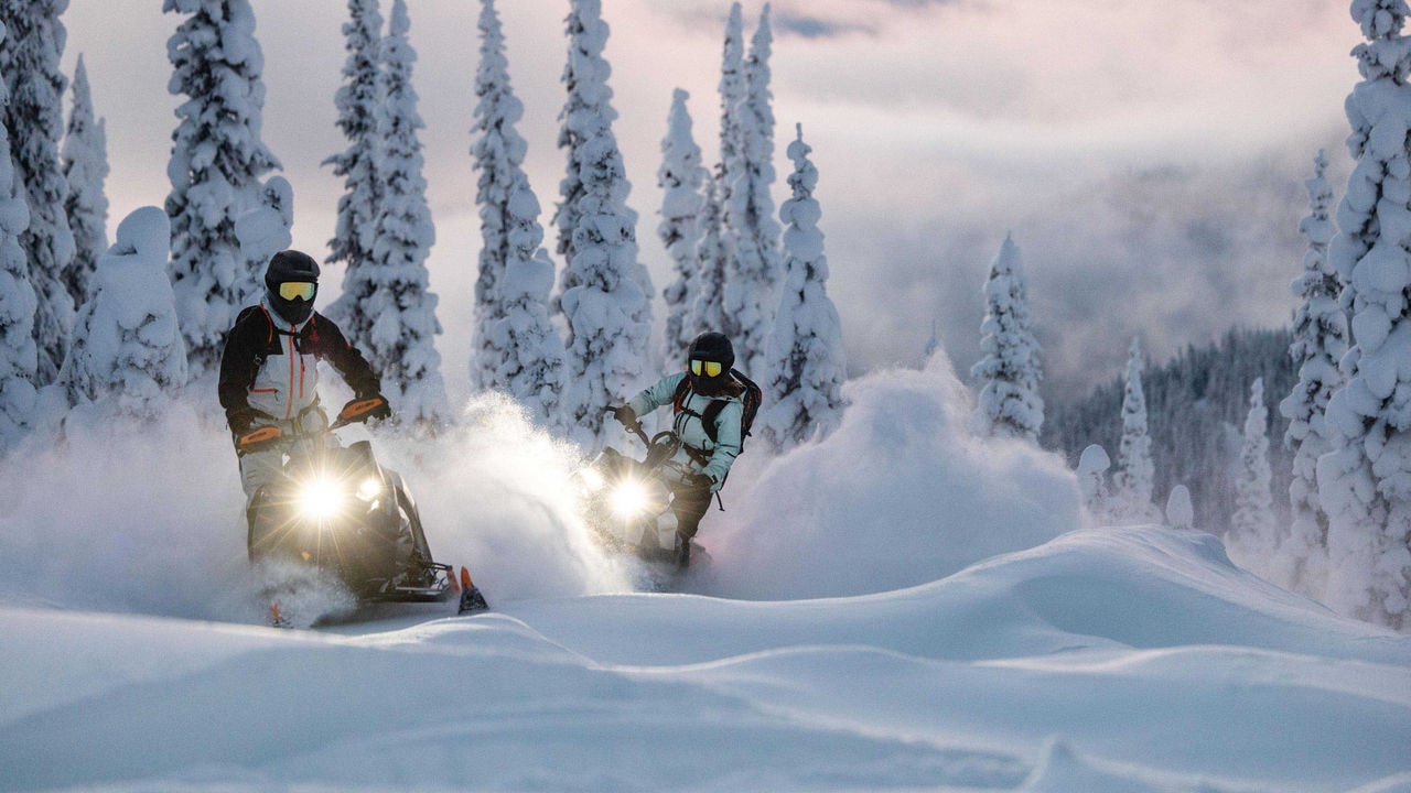 Two Ski-Doo riders in deep snow