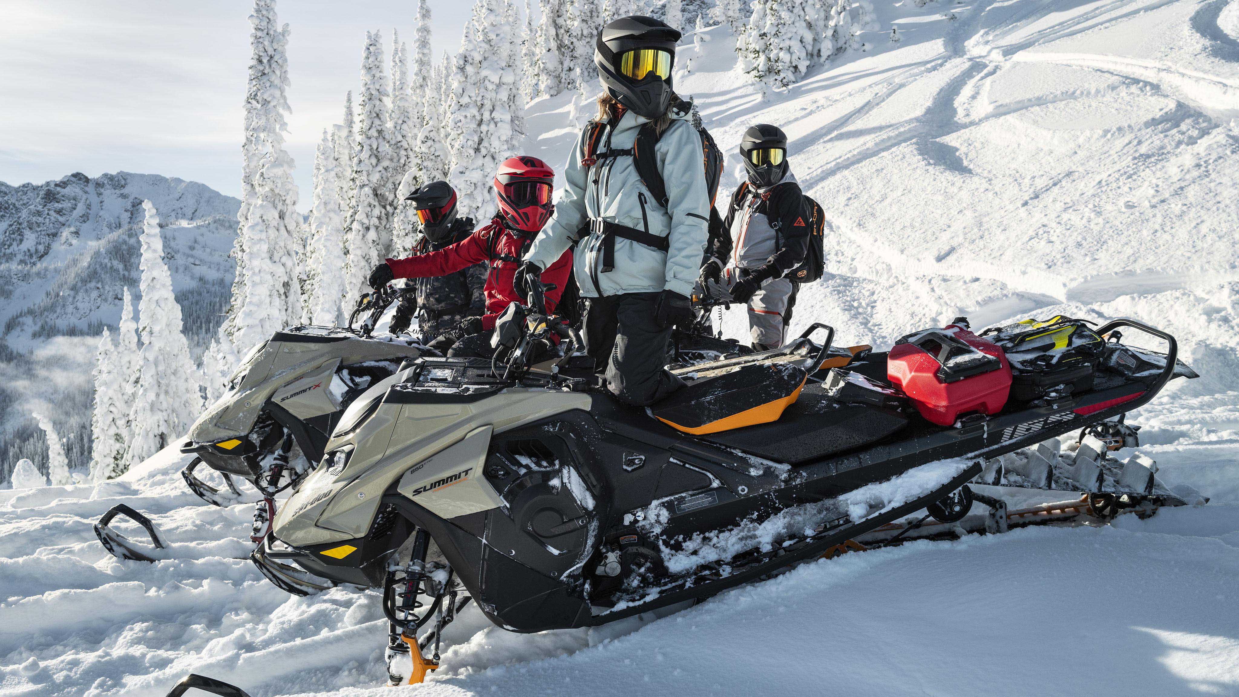 Skupina jazdcov na snežných skútroch v horách