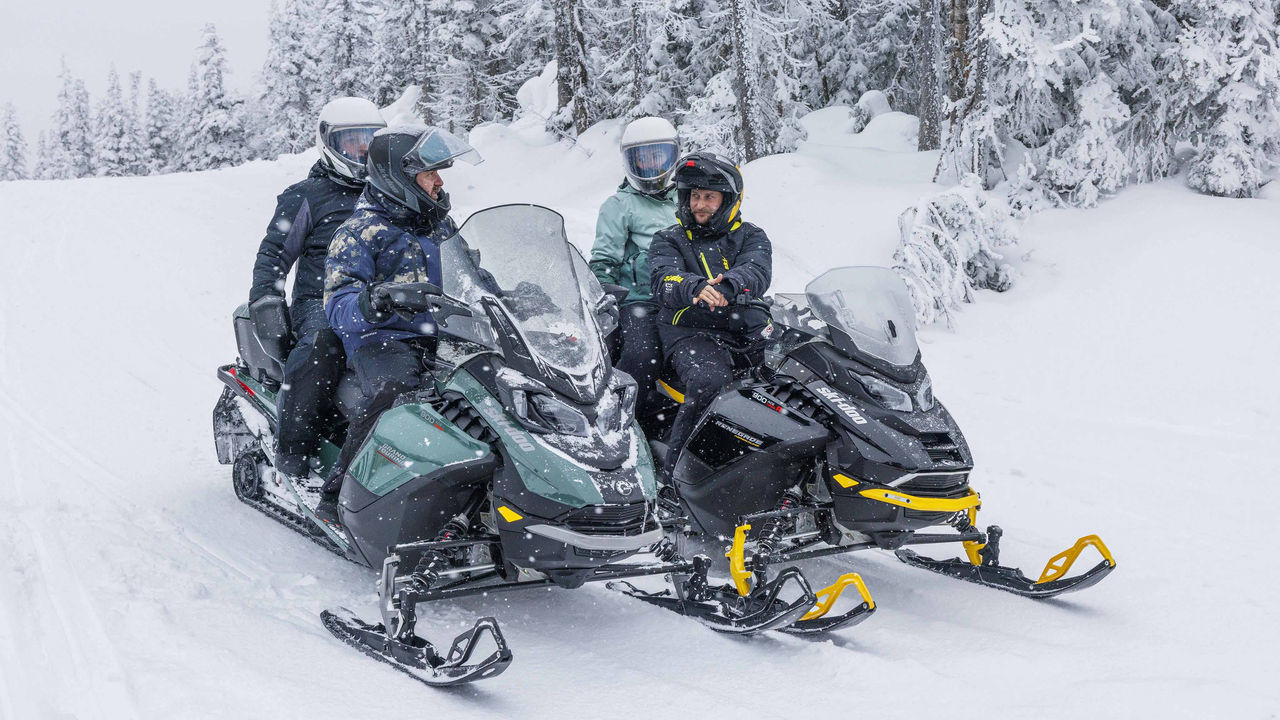 Group of snowmobile riders enjoying a break on the trail
