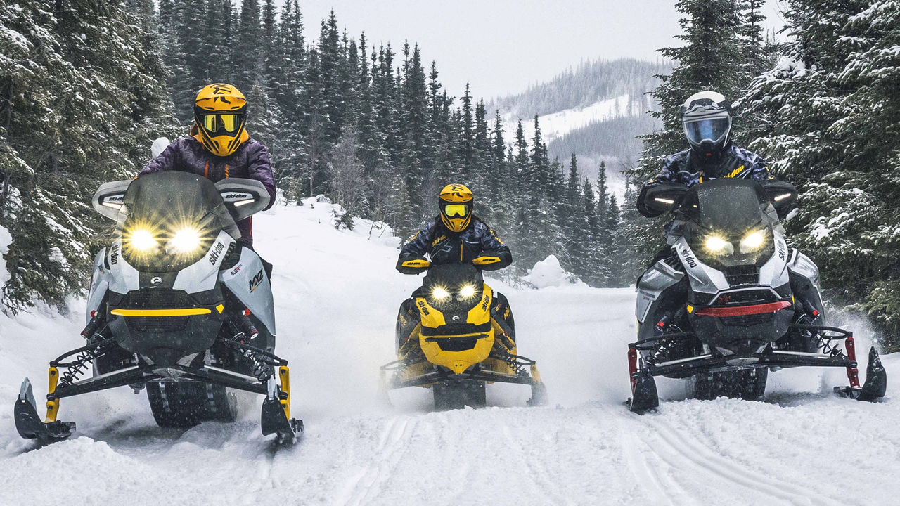 Three Ski-Doo riders on their sleds