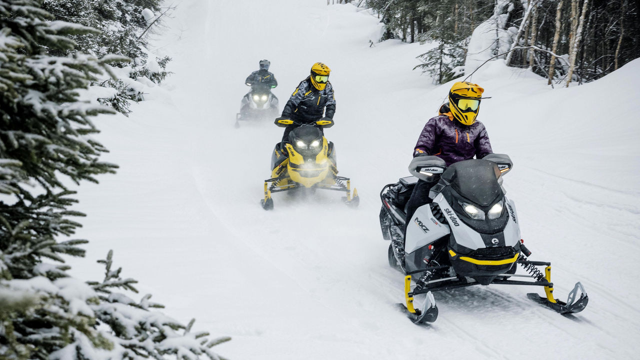 Traja jazdci Ski-Doo na traili