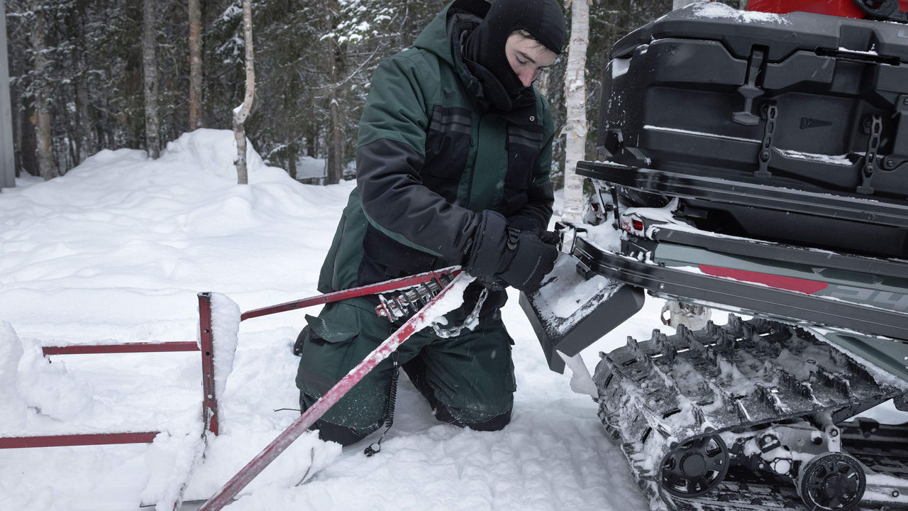 Man preppring the winch of his Skandic SE to tow