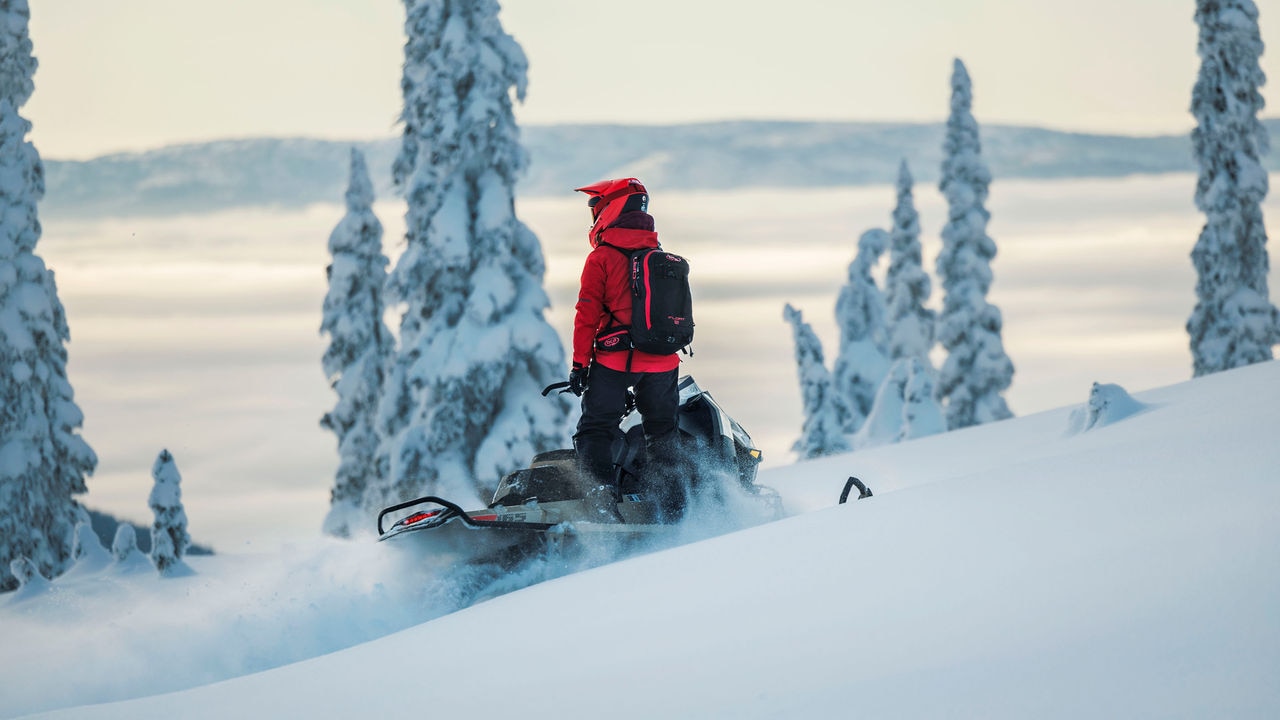 Bir dağın tepesindeki Ski-Doo Zirvesi'nde duran kullanıcı.