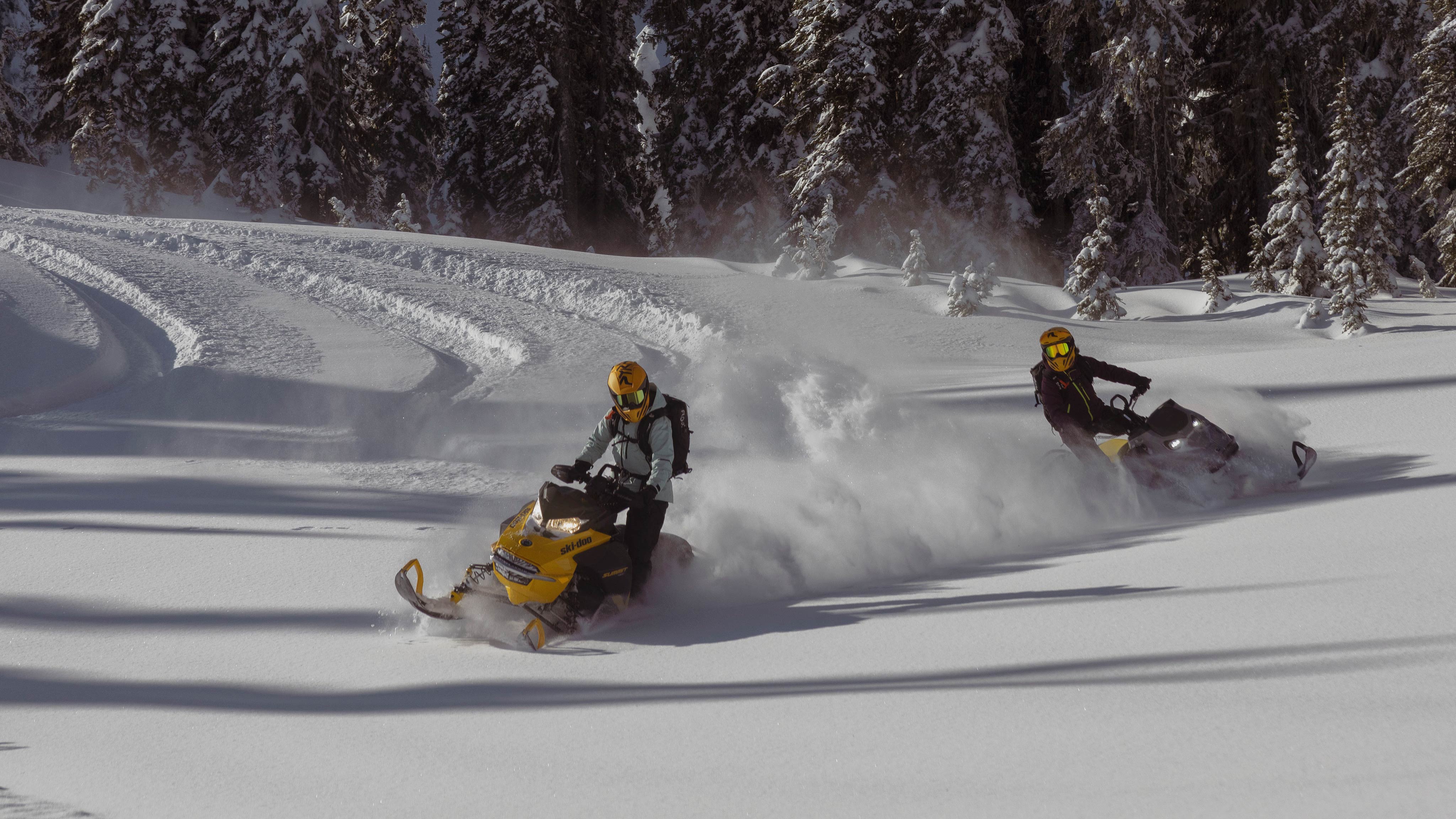 Dva skútre 2025 Ski-Doo jazdia v hlbokom snehu