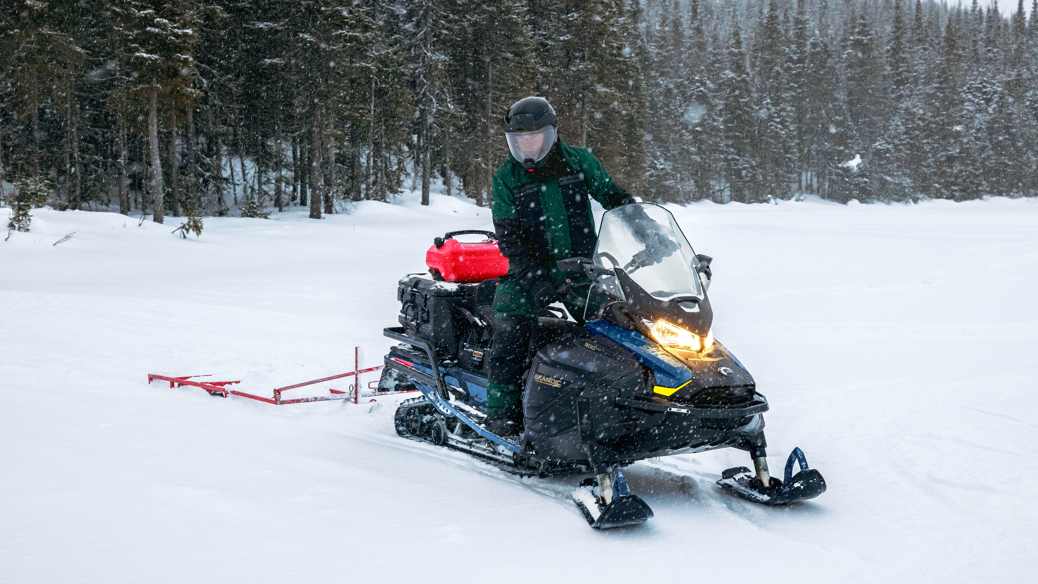 Muž ťahá sánky s jeho 2025 Ski-Doo Skandic