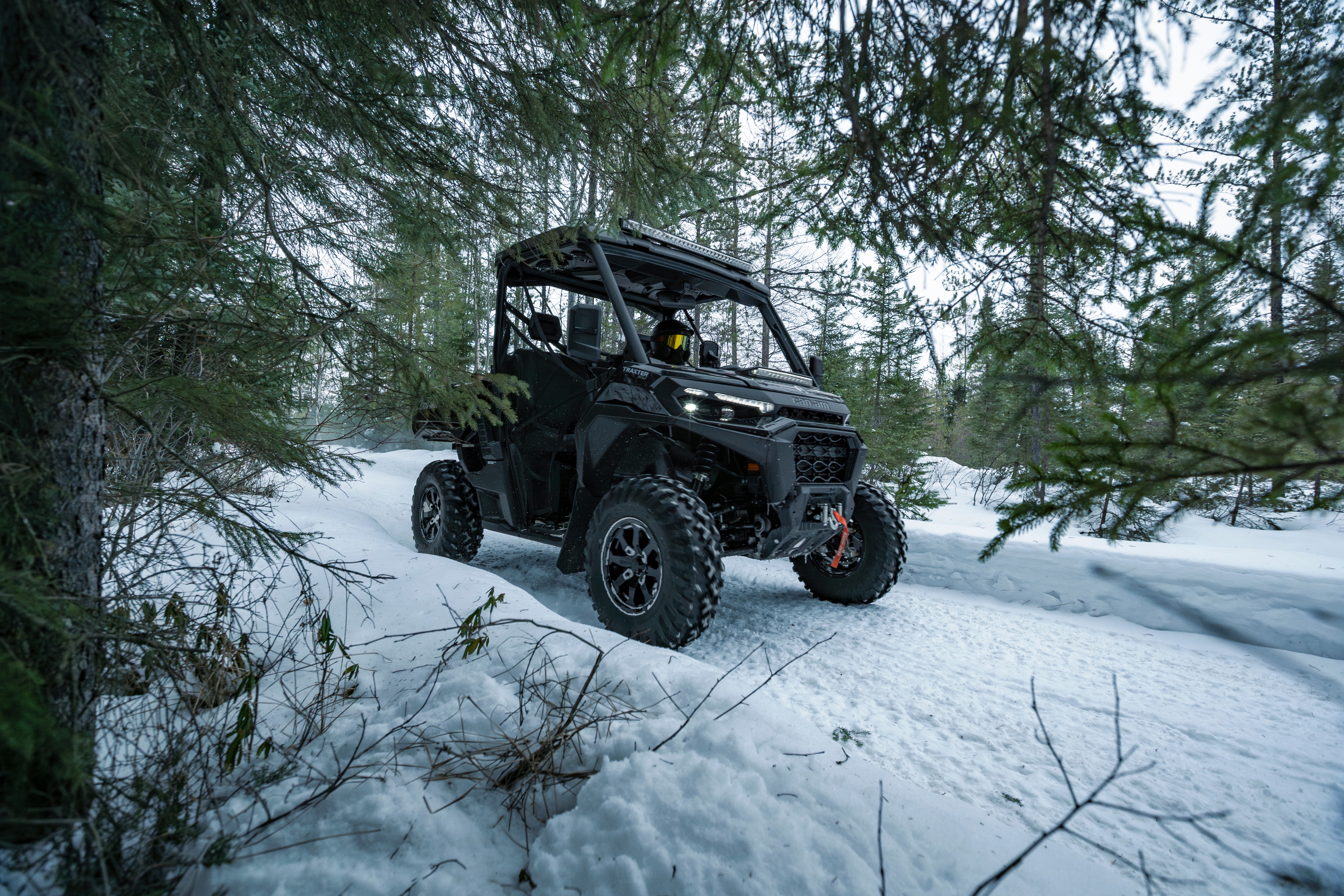 A Can-Am Traxter XU HD1 riding through a snowy trail