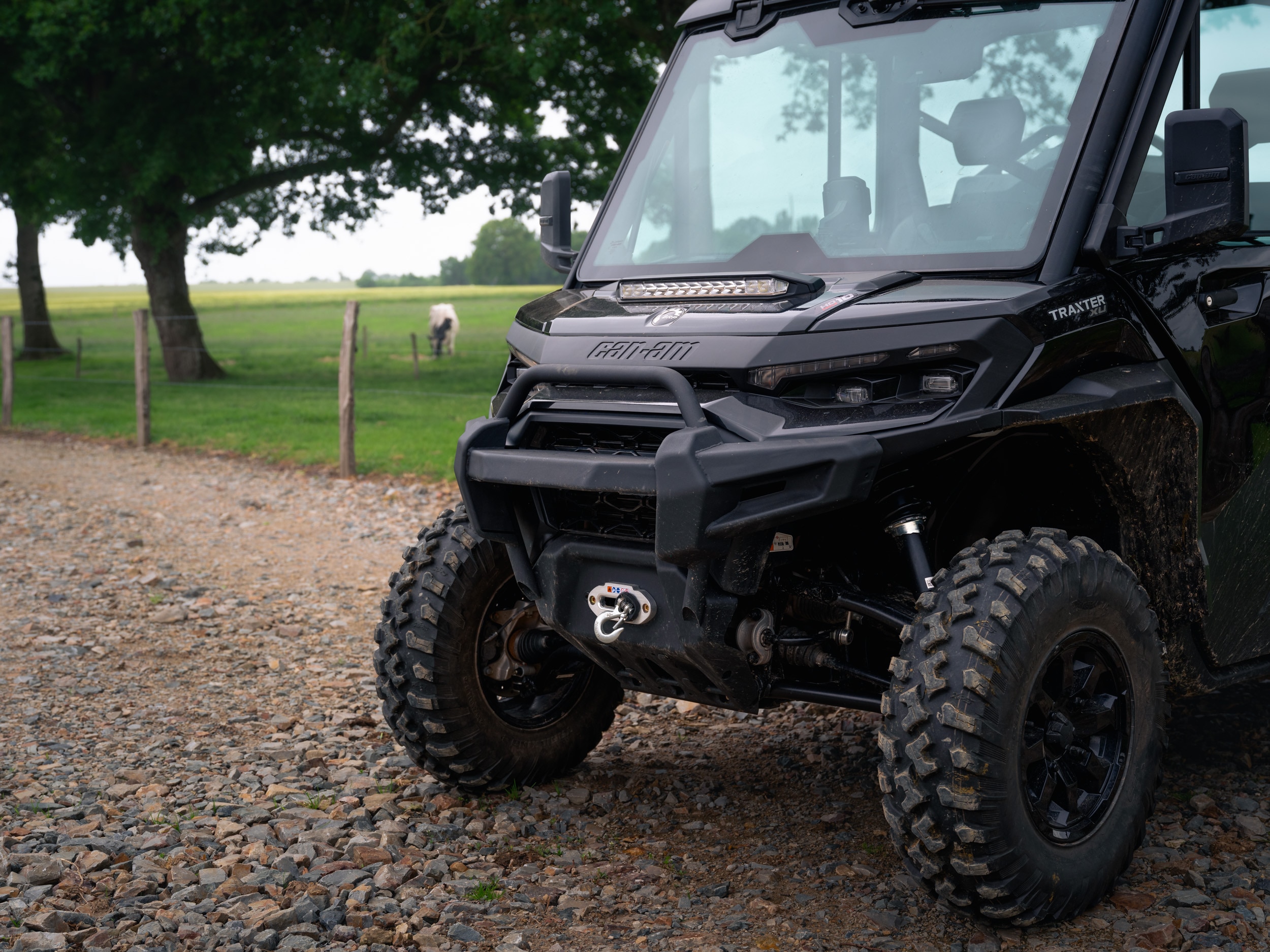 Can-Am Traxter XU parked on a dirt road next to a field