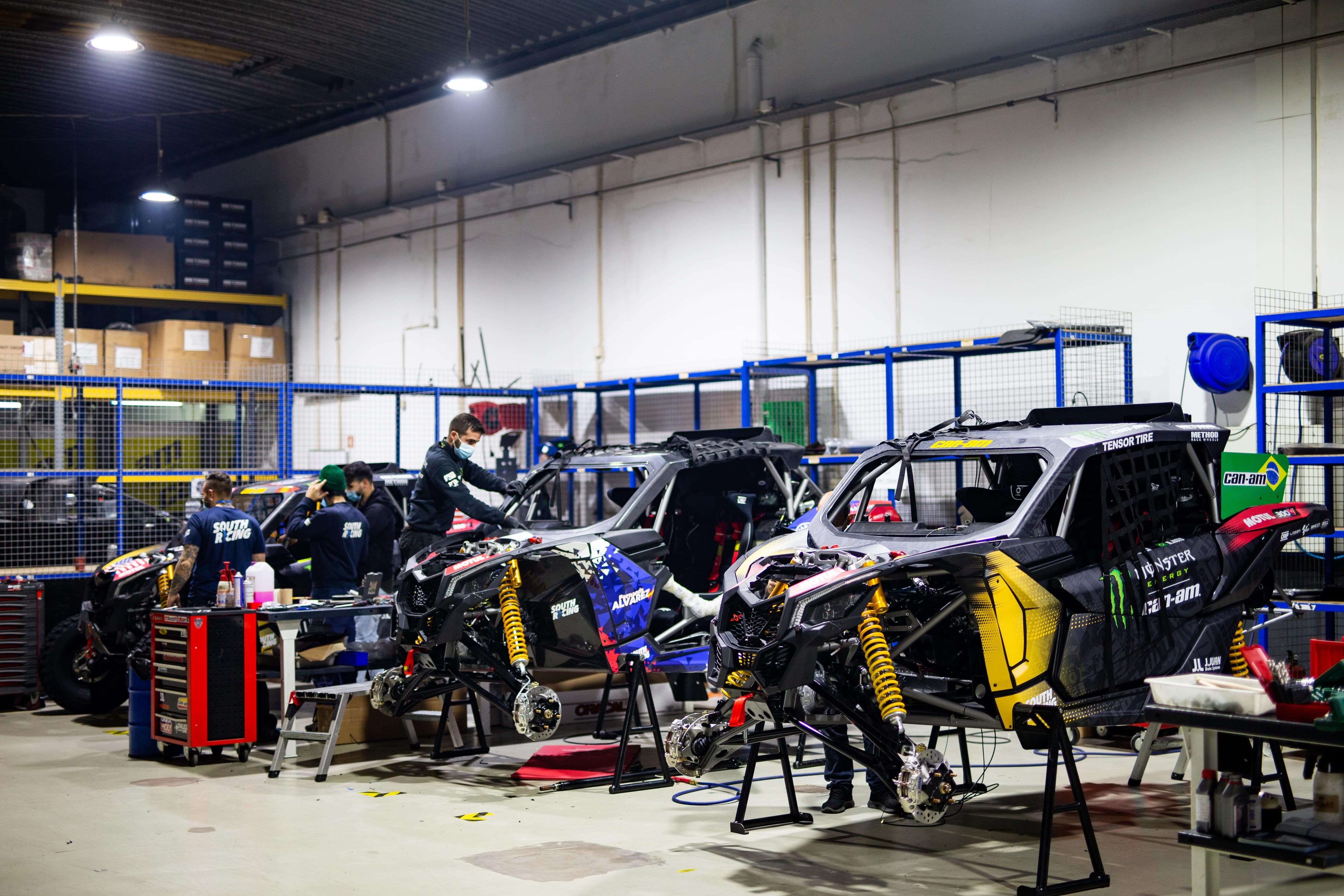 People preparing Can-Am Maverick X3 vehicles for 2021 Dakar Rally
