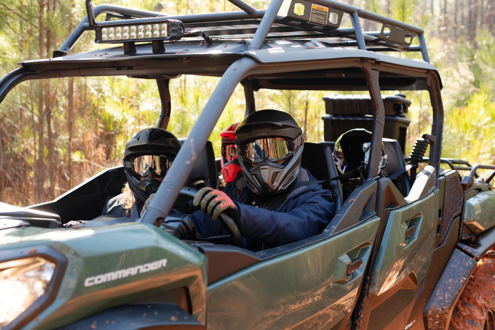 Close up of the driver in a green Commander MAX loaded with passengers on a wooded background