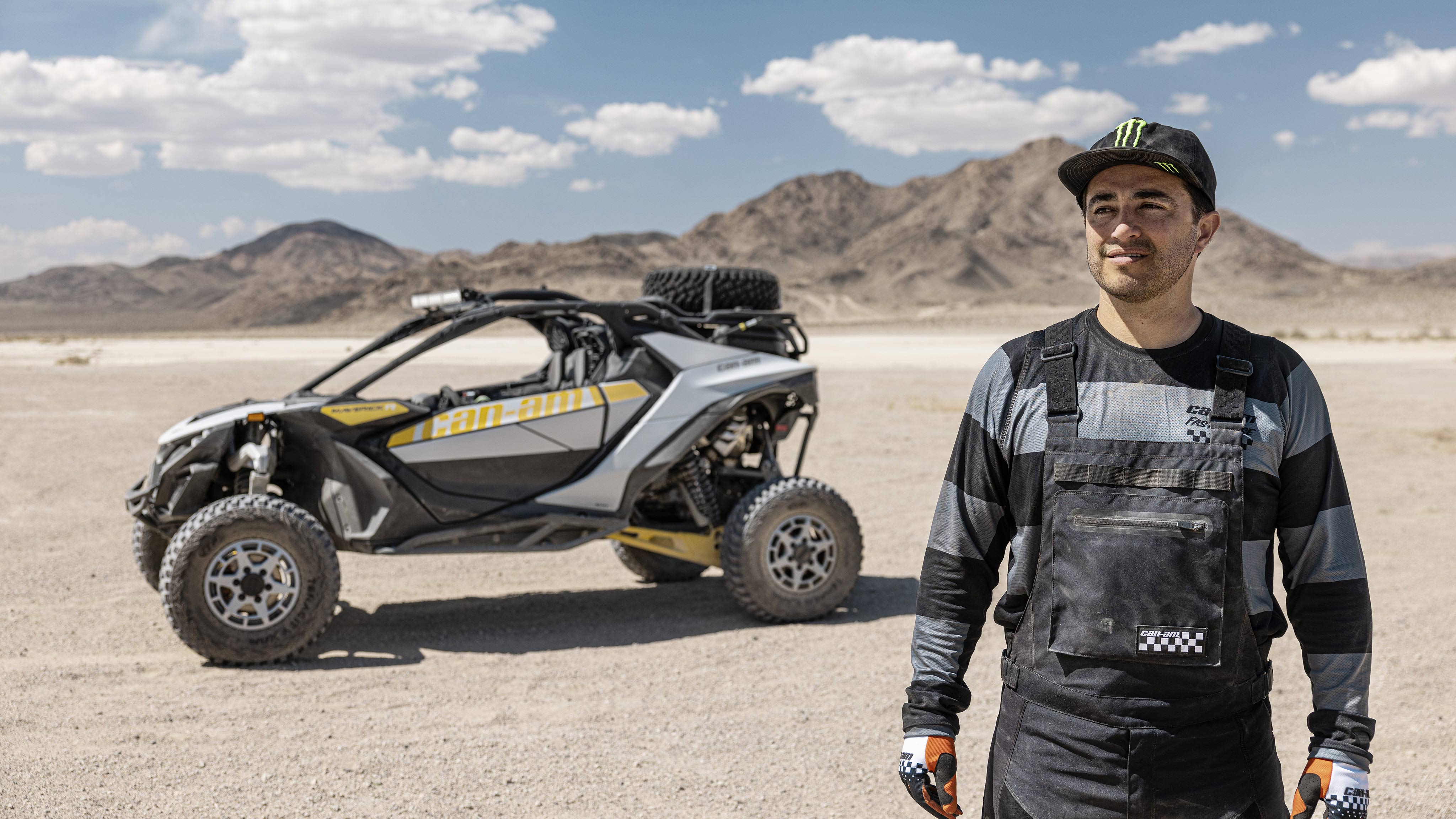 A man in the desert with his Can-Am Maverick R SxS in the background