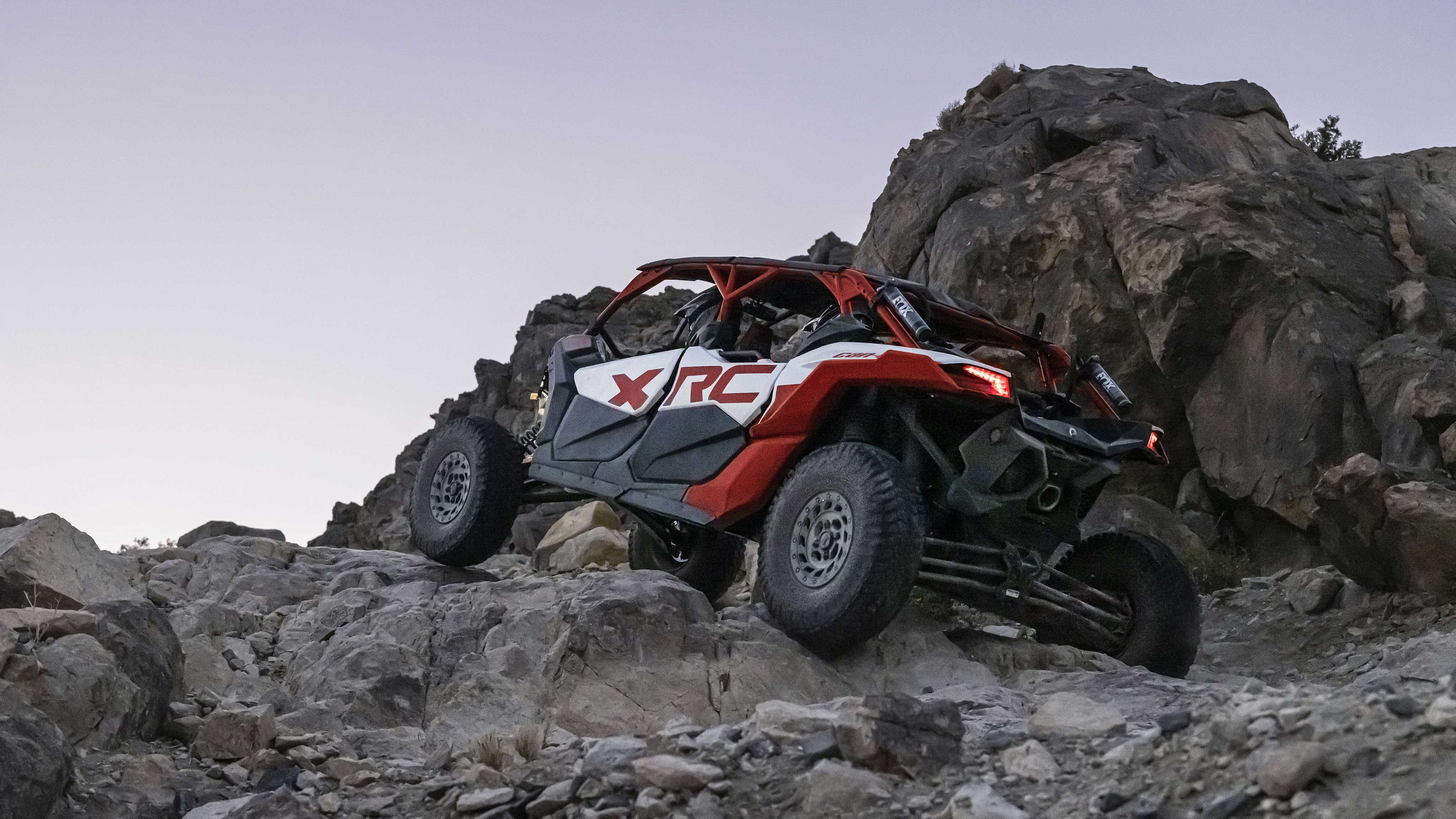 A Can-Am Maverick X3 Max X RC climbing over rocks