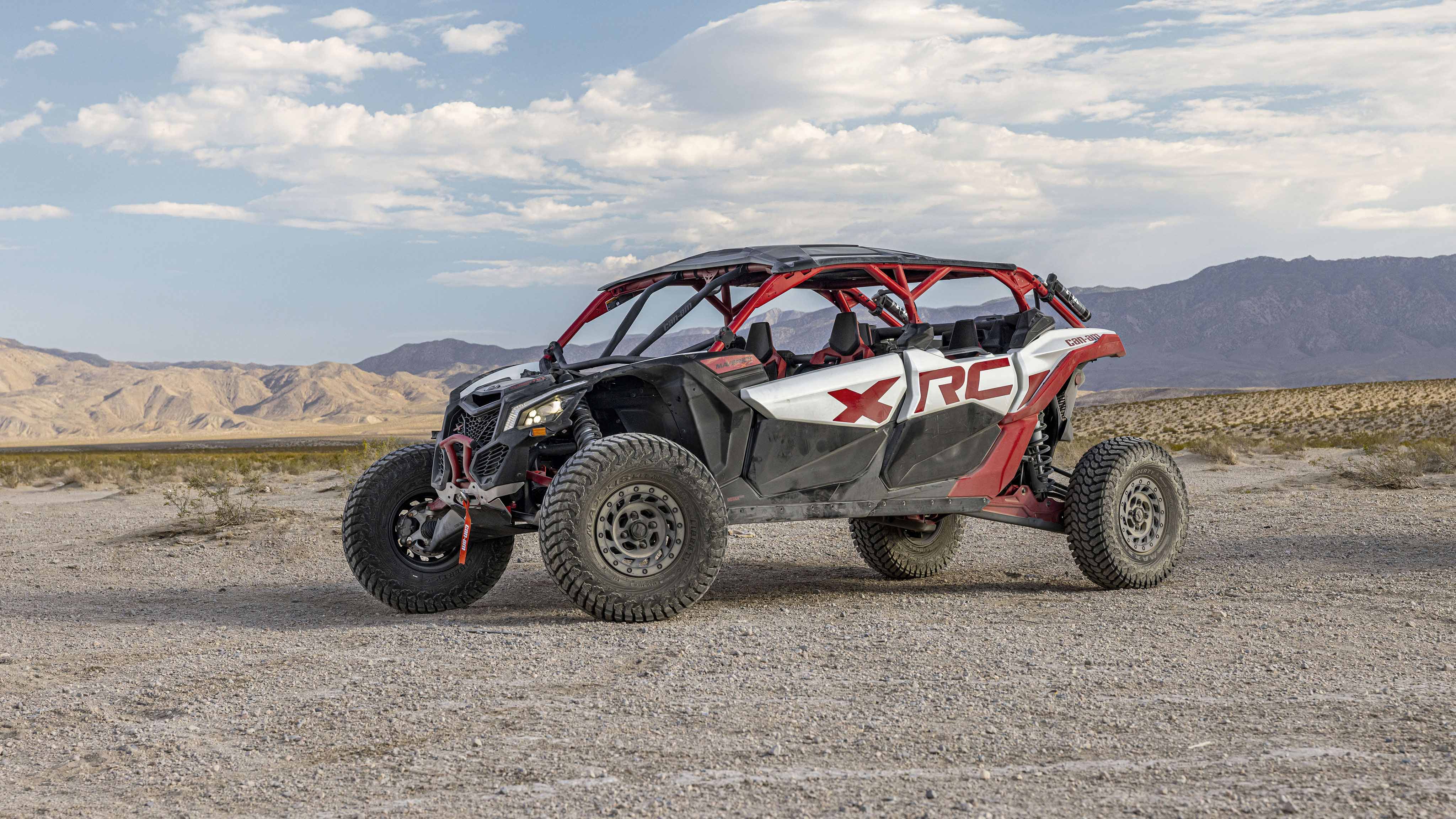 A dusty Can-Am Maverick SxS parked on a dirt road