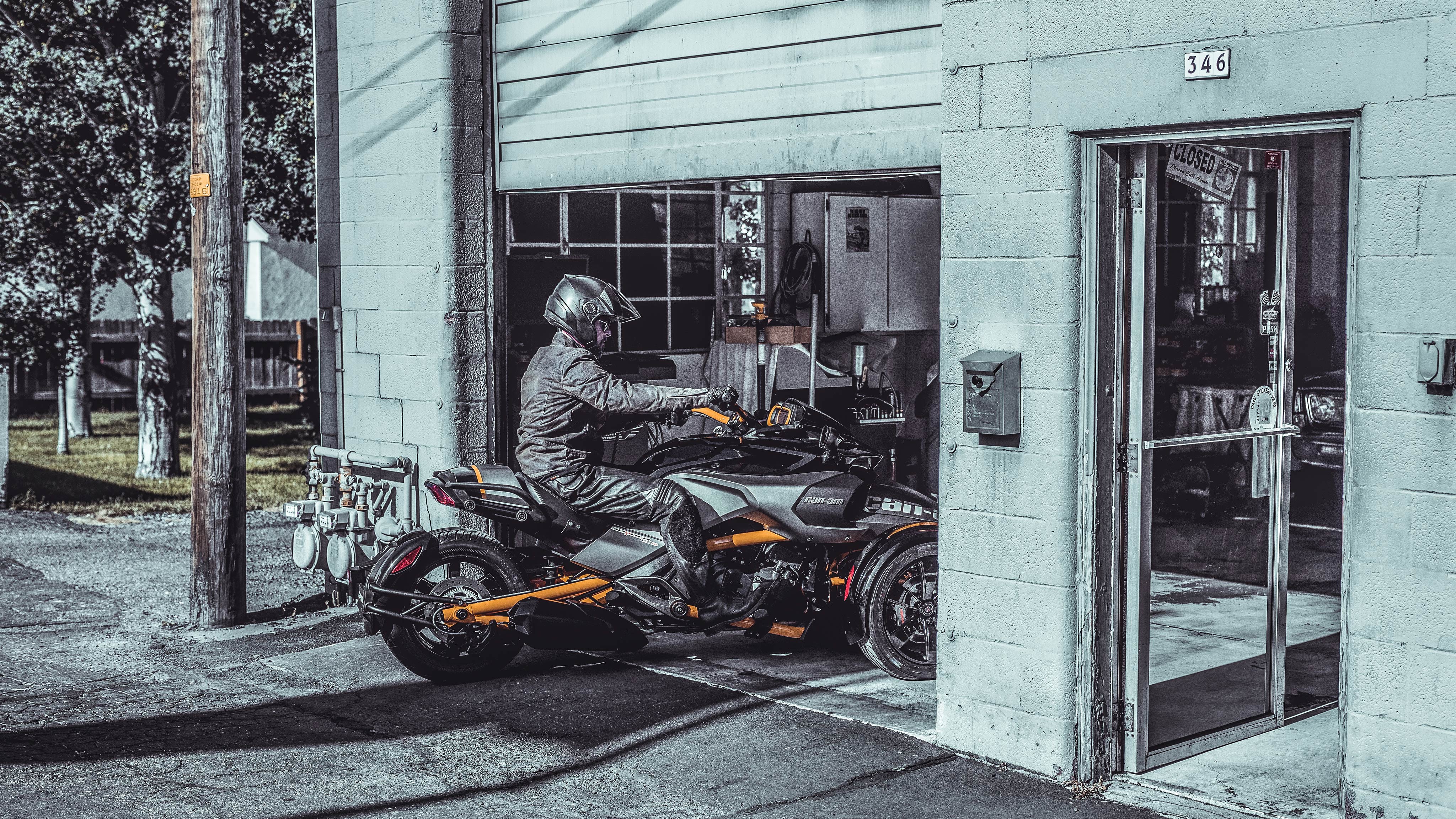 A man driving his Can-Am vehicle into a garage