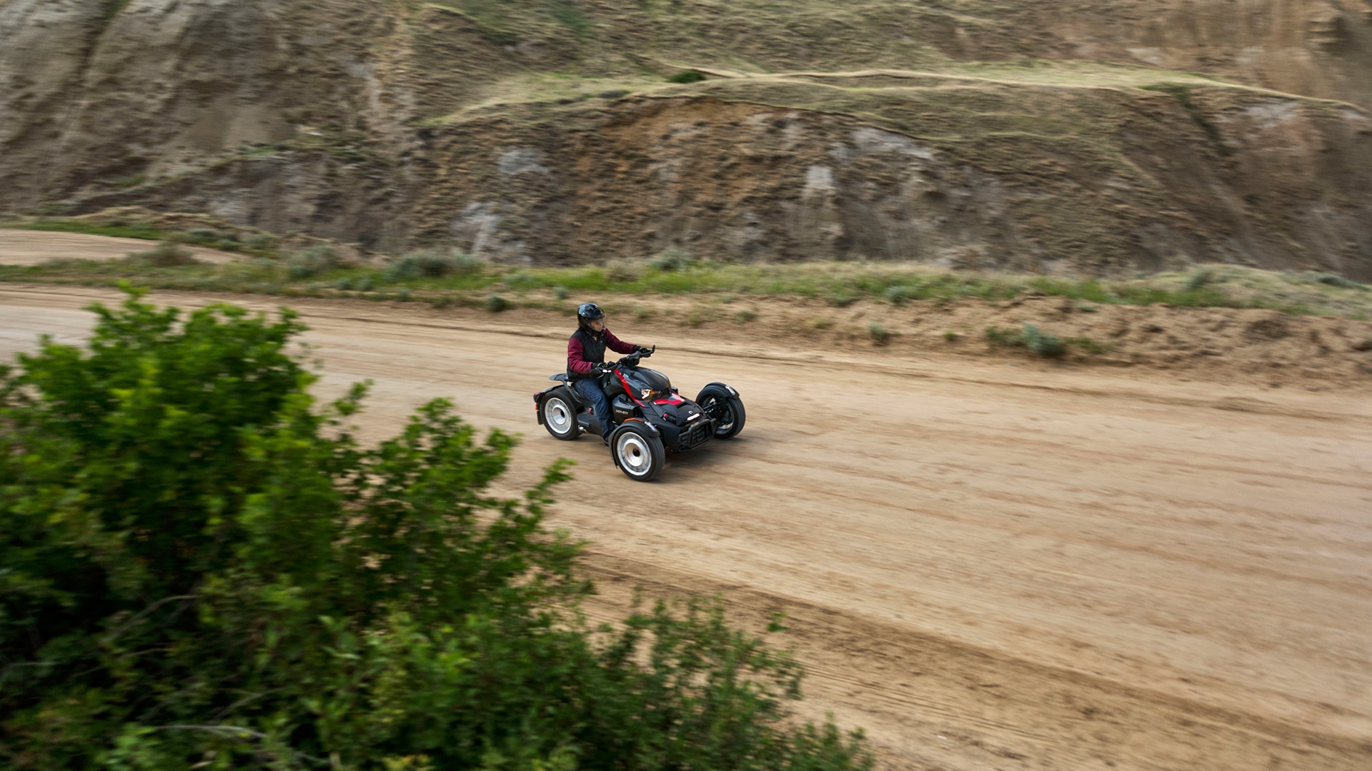 Can-Am 3-wheel motorcycle riding on a dirt road