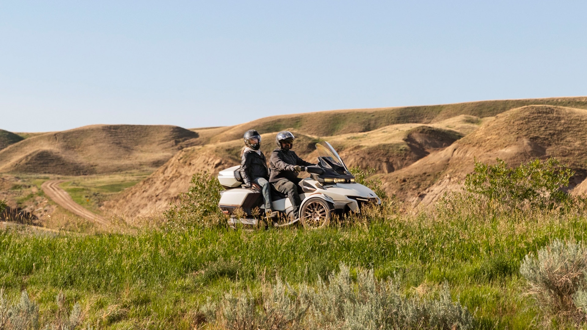 Two riders driving on their Can-Am Spyder RT next to a valley