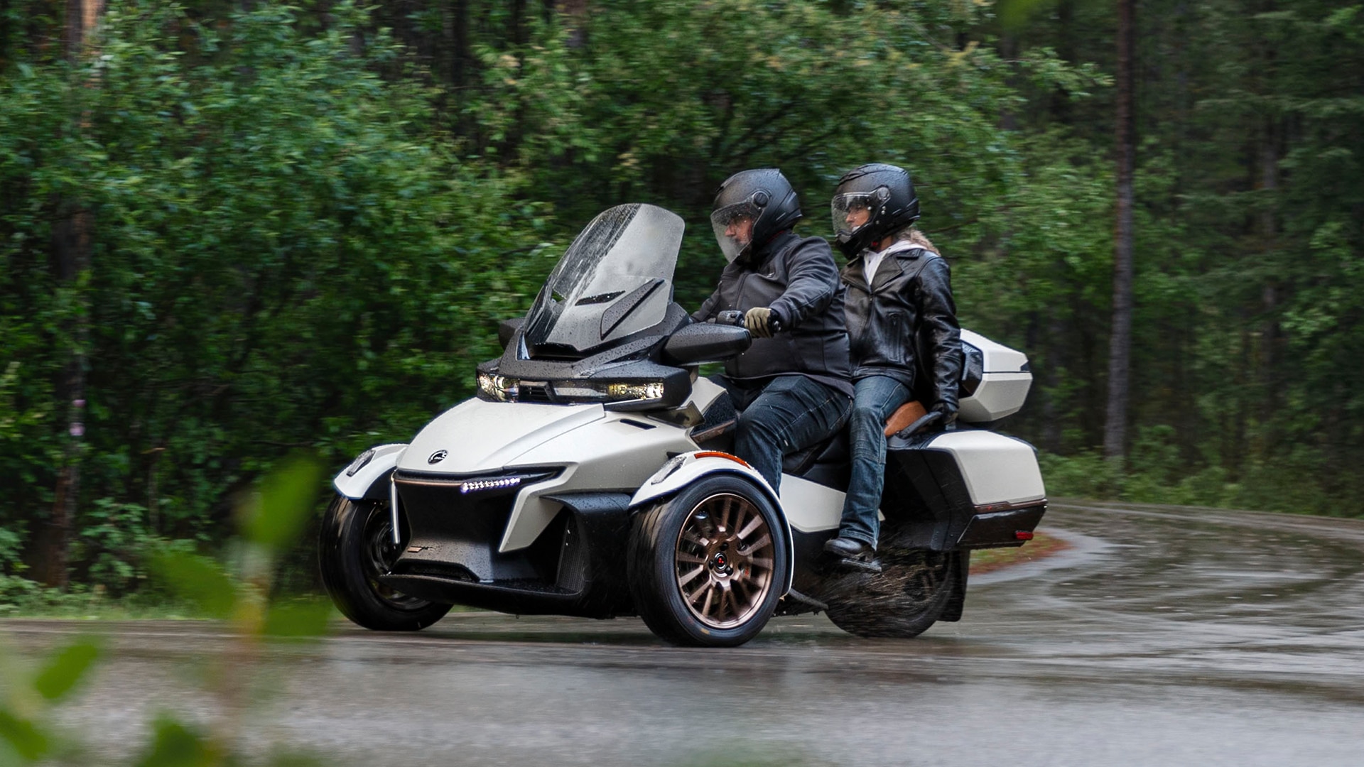 Can-Am Spyder RT in a tight turn on a rainy road in a forest