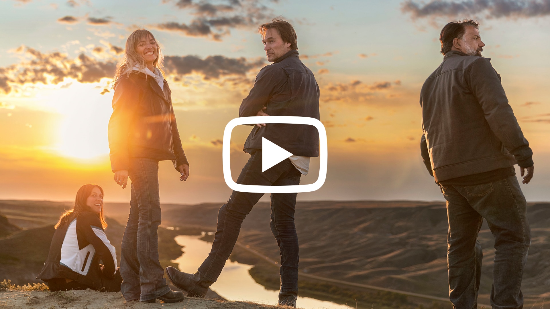 Four people posing next to a canyon with a Youtube logo over the image