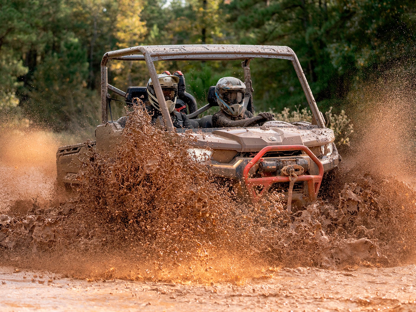 Can-Am Off-Road Defender SxS vehicle riding in a mud hole