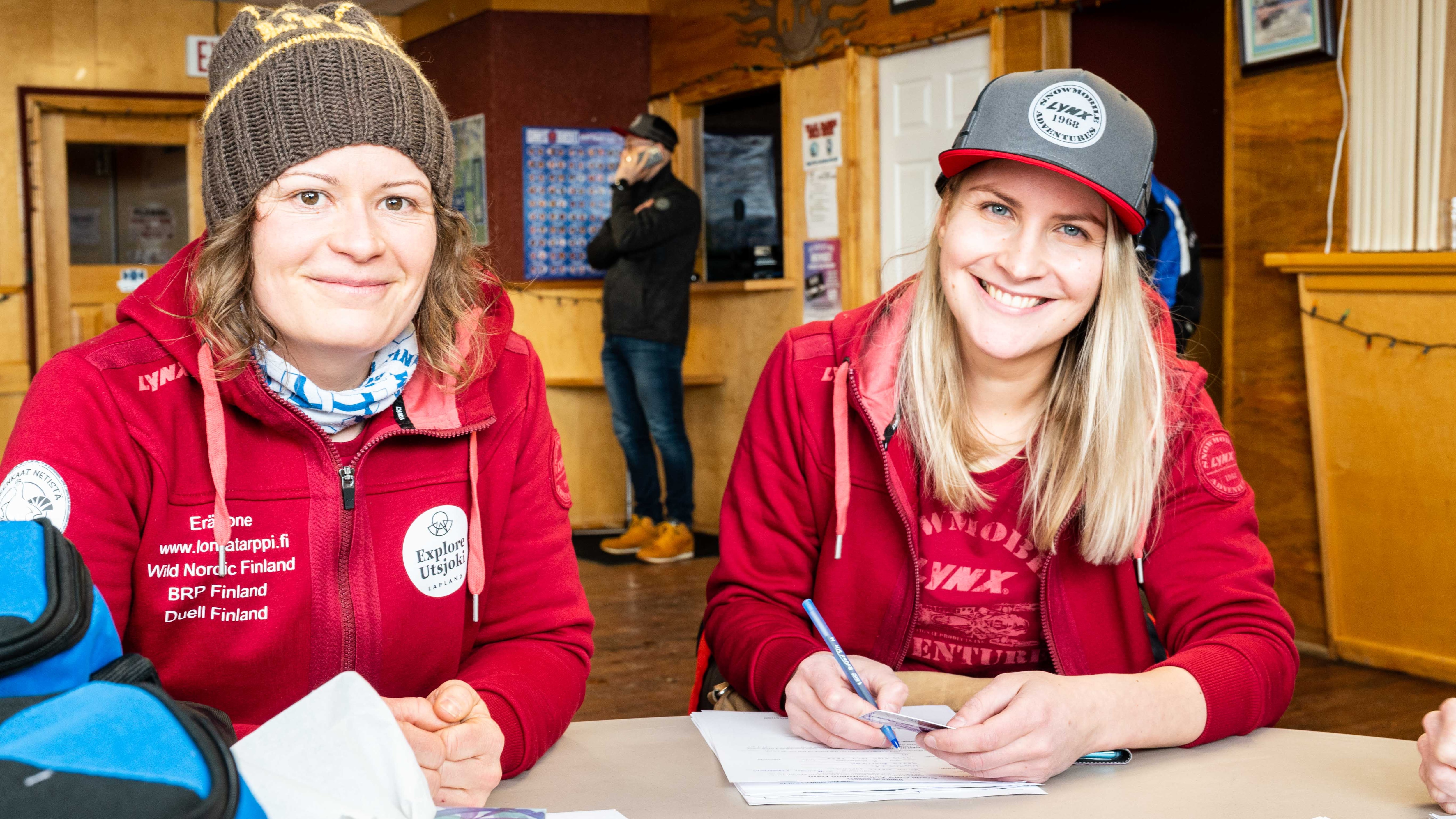 Two Finnish ladies smiling and signing documents