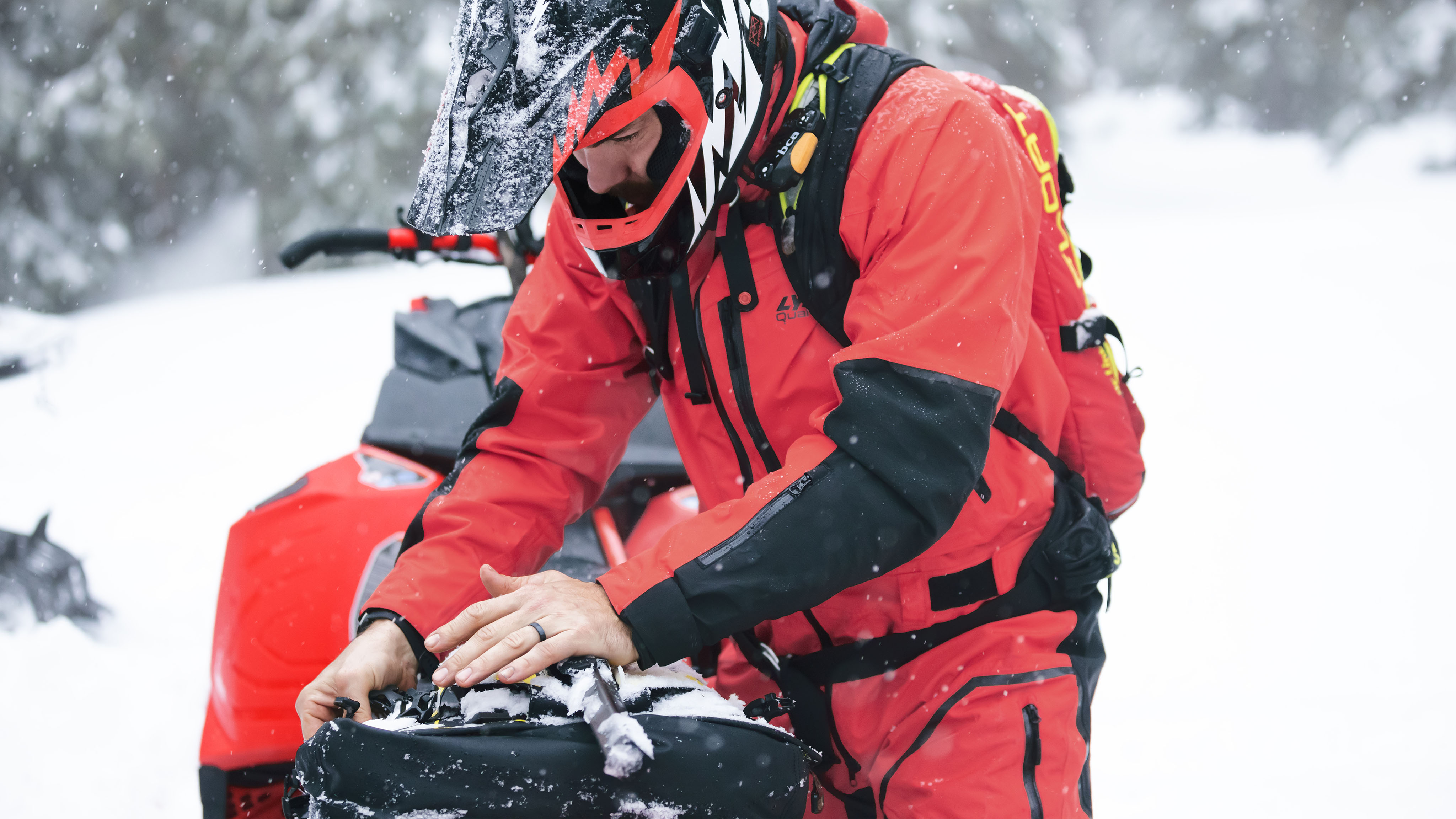 Man wearing Lynx Apparel and preparing a snowmobile ride