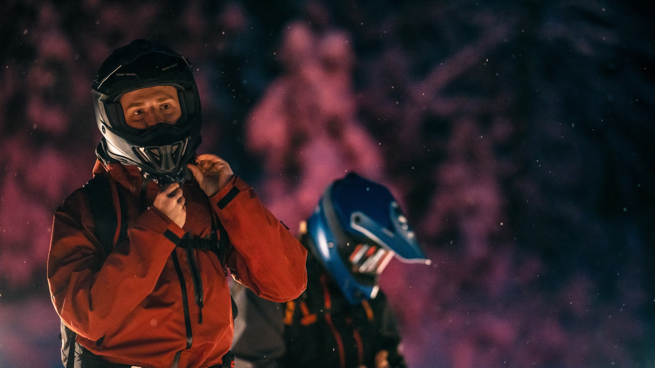 Muž si nasadzuje prilbu pred jazdou na snežnom skútri