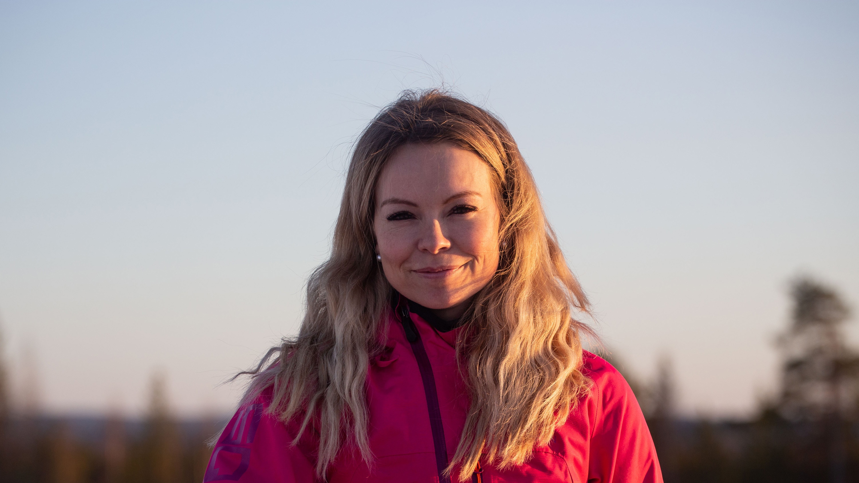 A women is sitting on a snowmobile with a smile