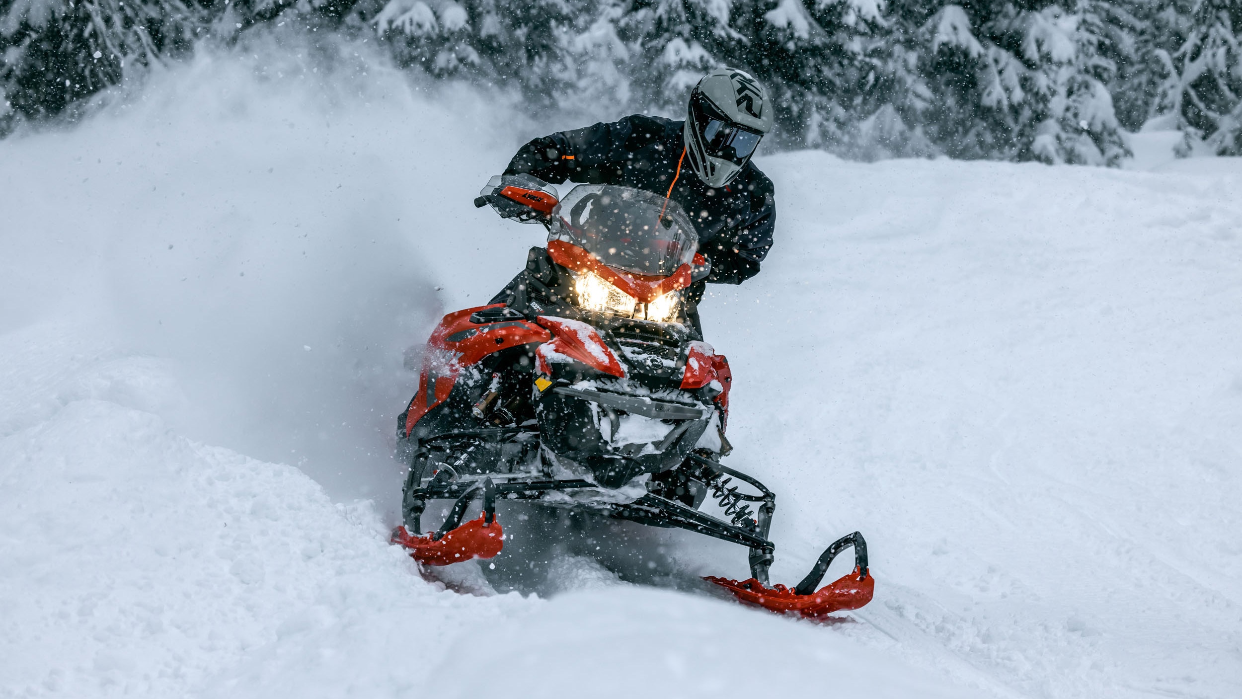Rider blowing some snow on their Lynx snowmobile