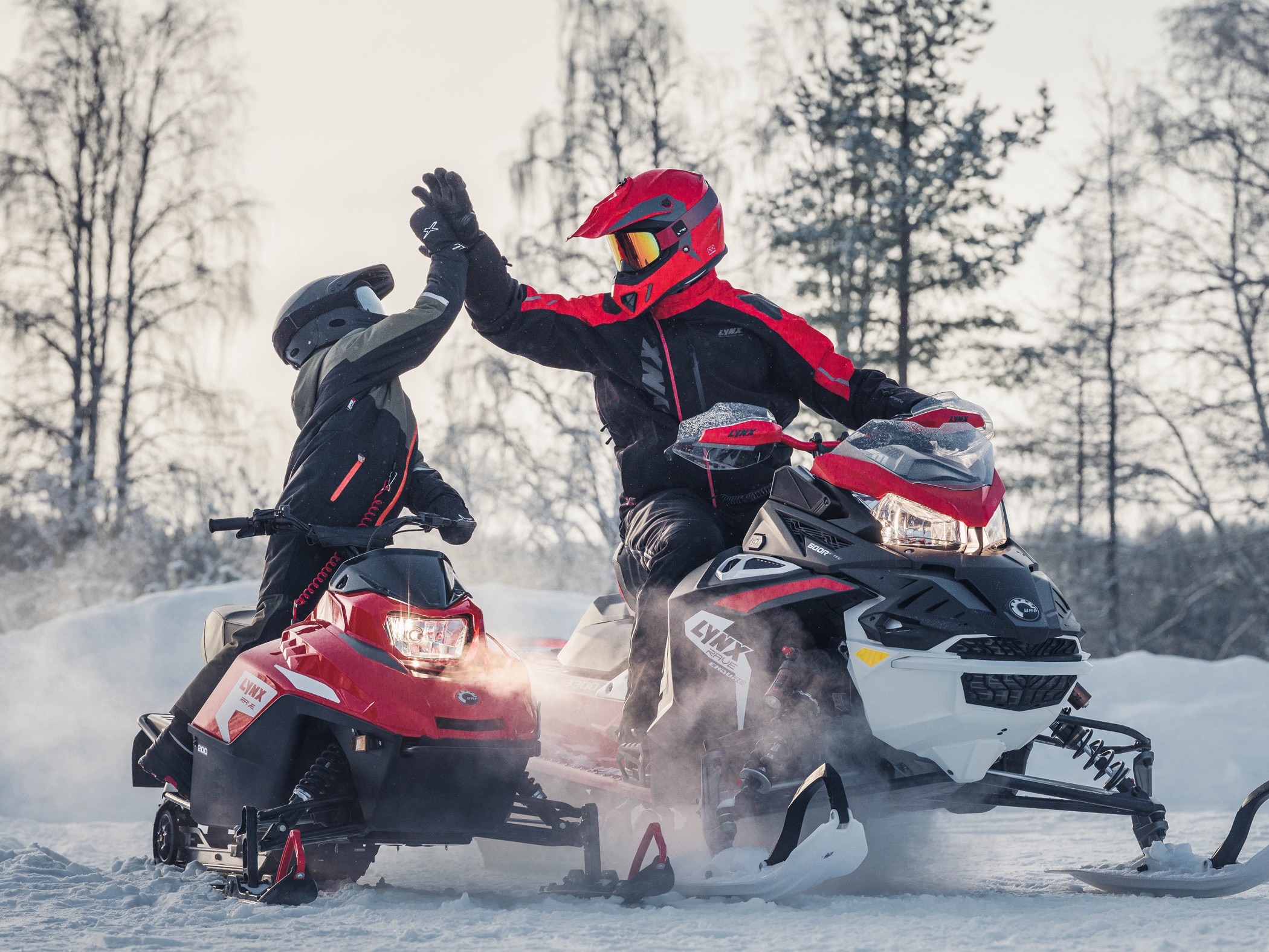 Man and child having fun on Lynx Snowmobiles