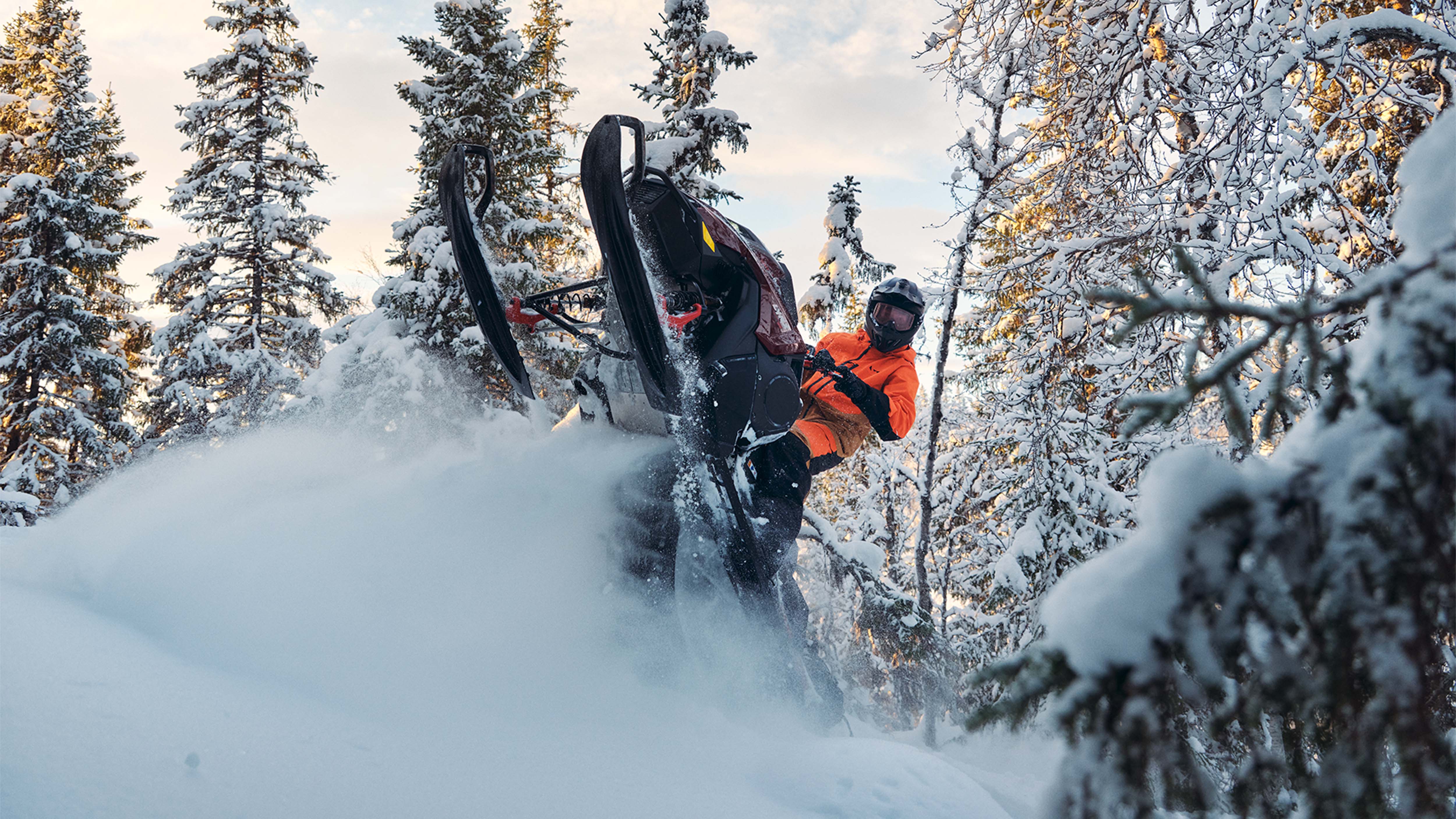Snežný skúter Lynx Shredder DS 2025 robí wheelie v hlbokom snehu v lese