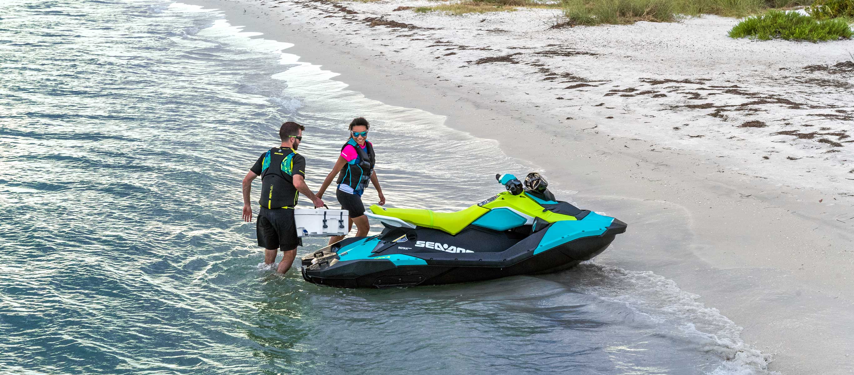 Couple going on a beach next to their Sea-Doo Spark 