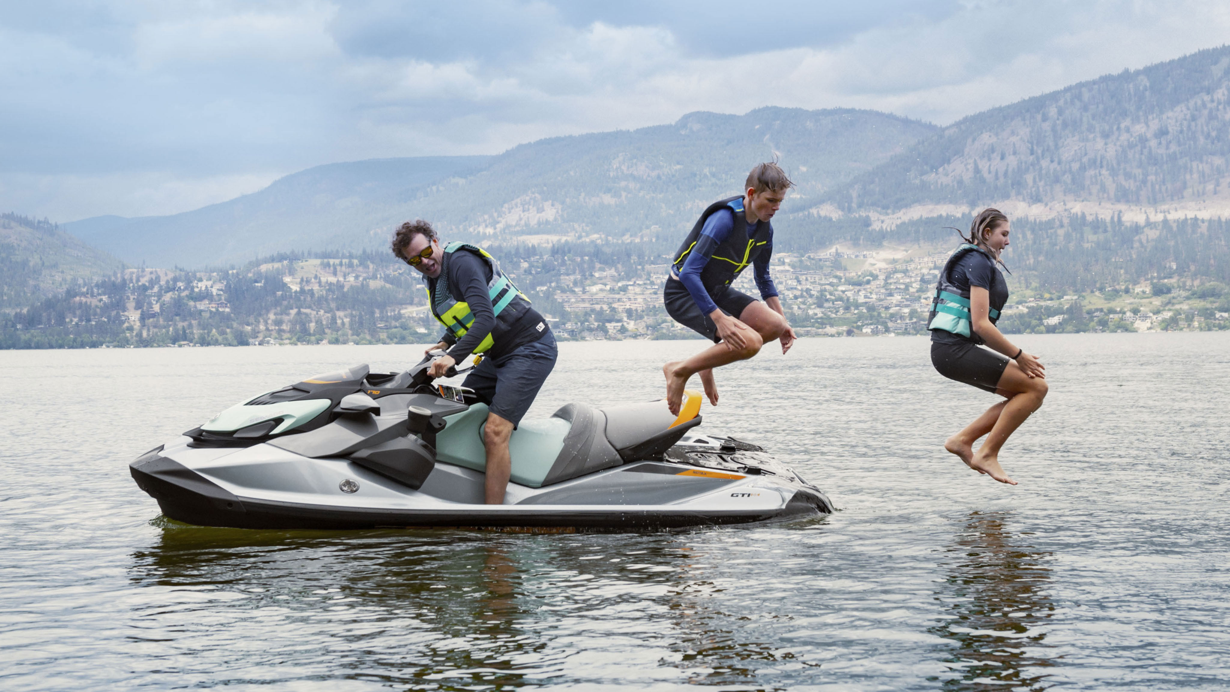 Otec na Sea-Doo GTI zatiaľ čo jeho deti skáču do vody