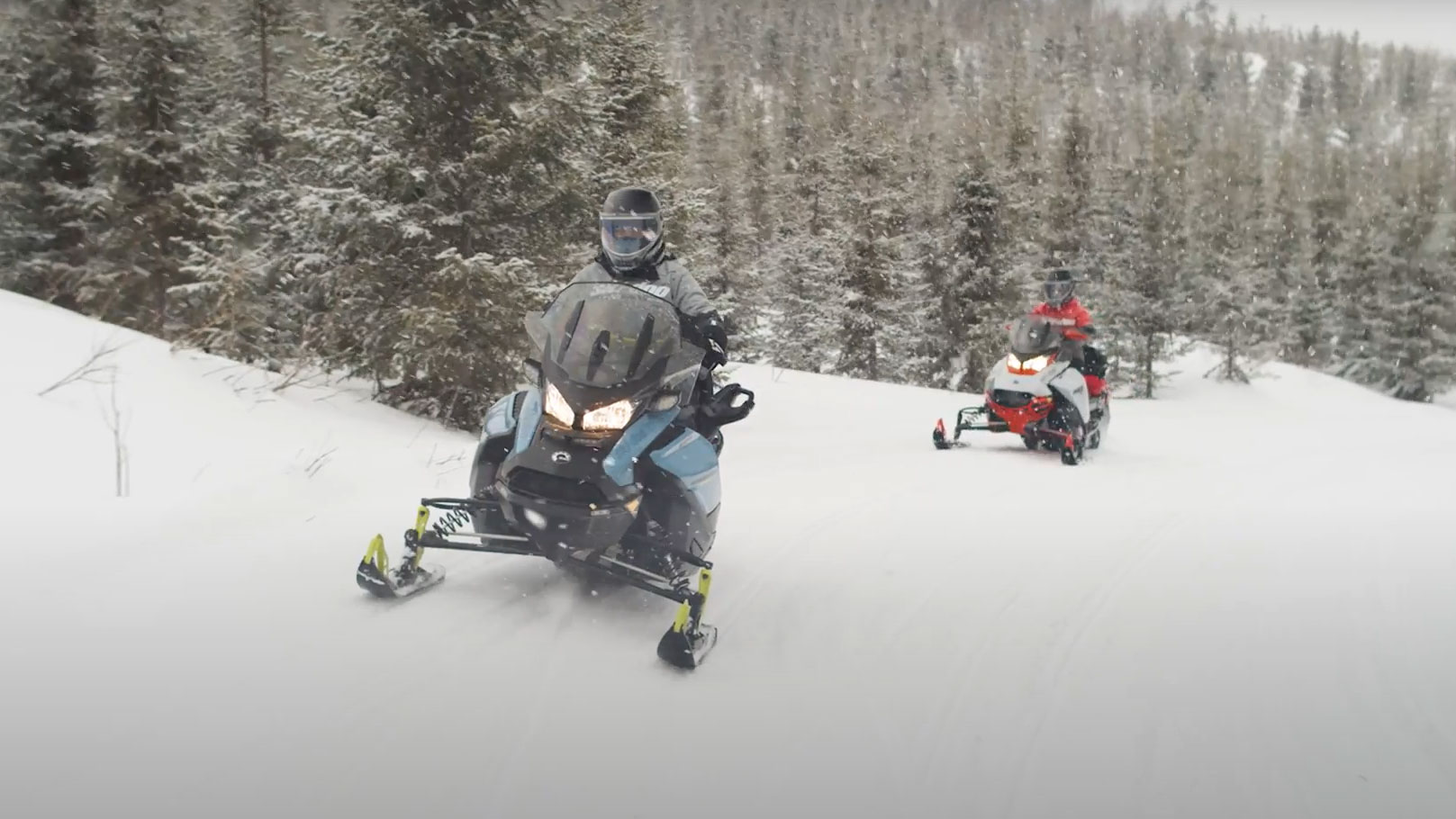 Две жени кои возат Ski-Doo моторни санки во длабочините на патеката.