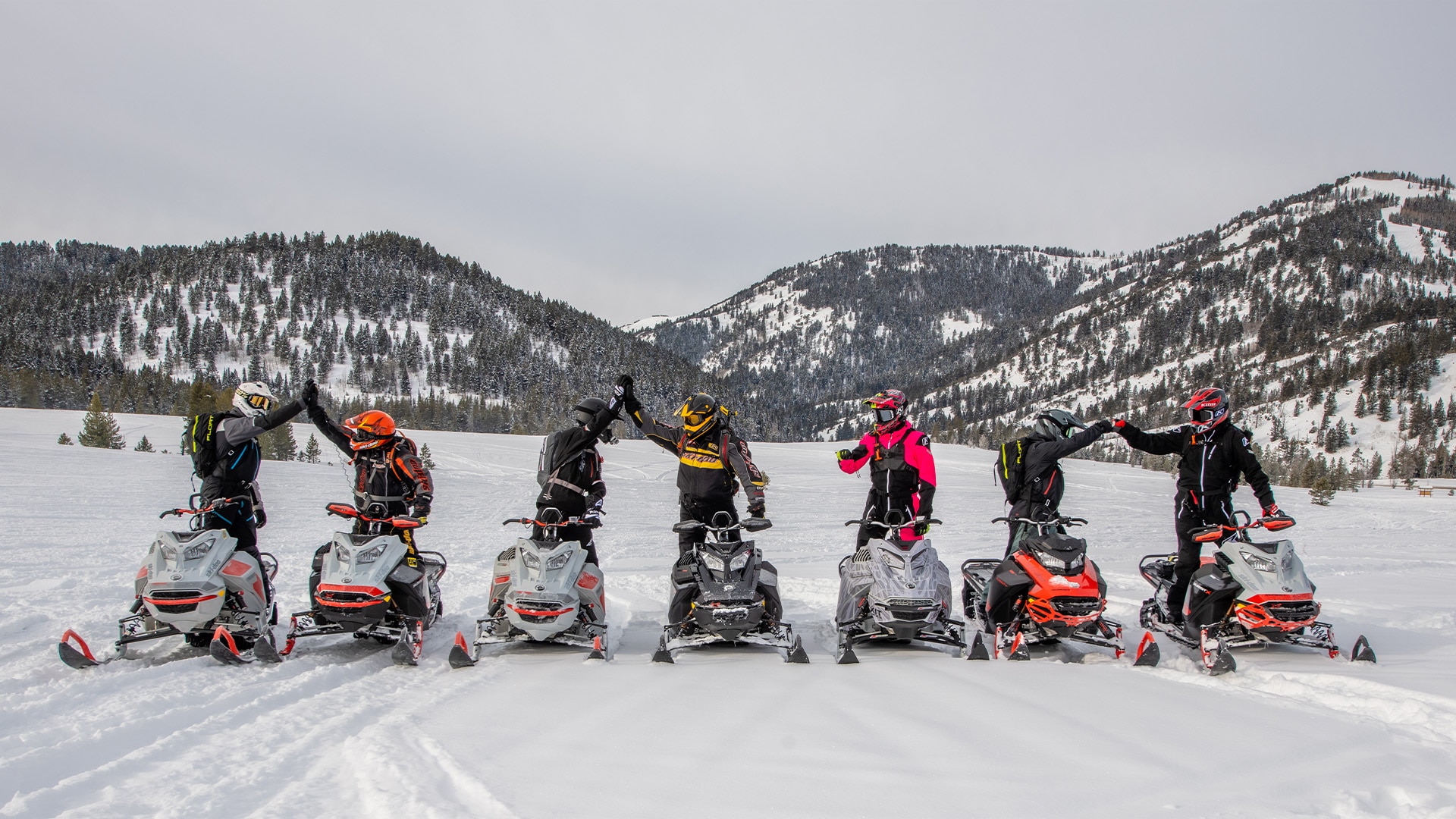 Group of happy people on Ski-Doo snowmobiles