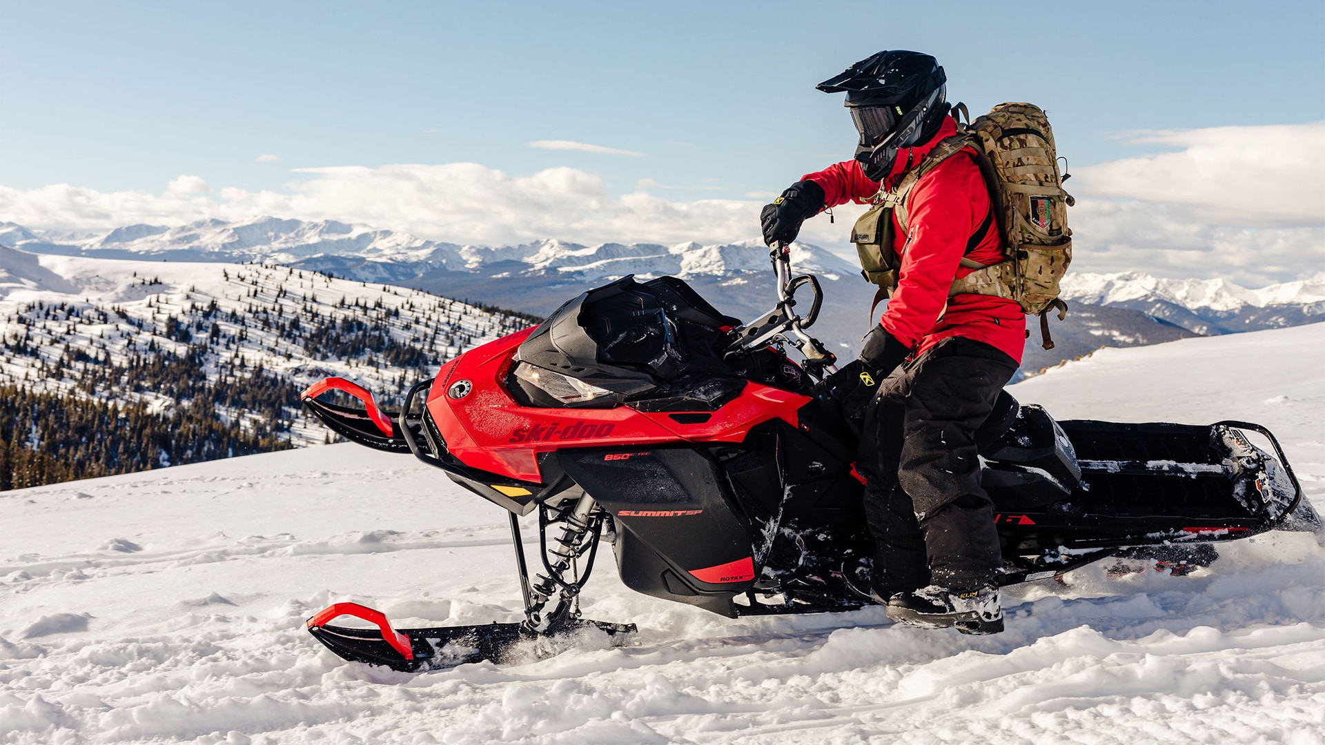 Возач на Ski-Doo моторна санка кој го освоил планината.